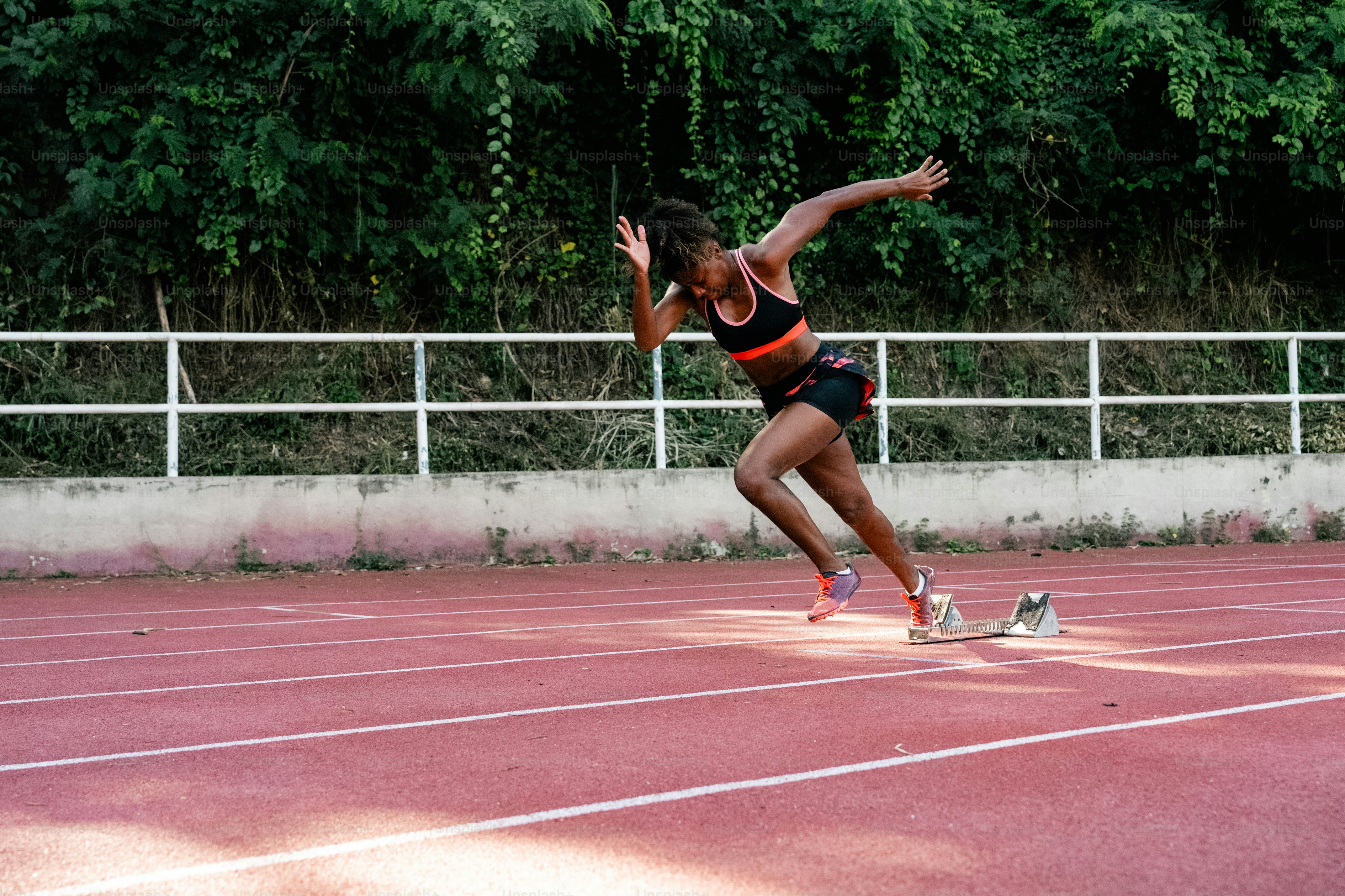 A woman is running on a red track