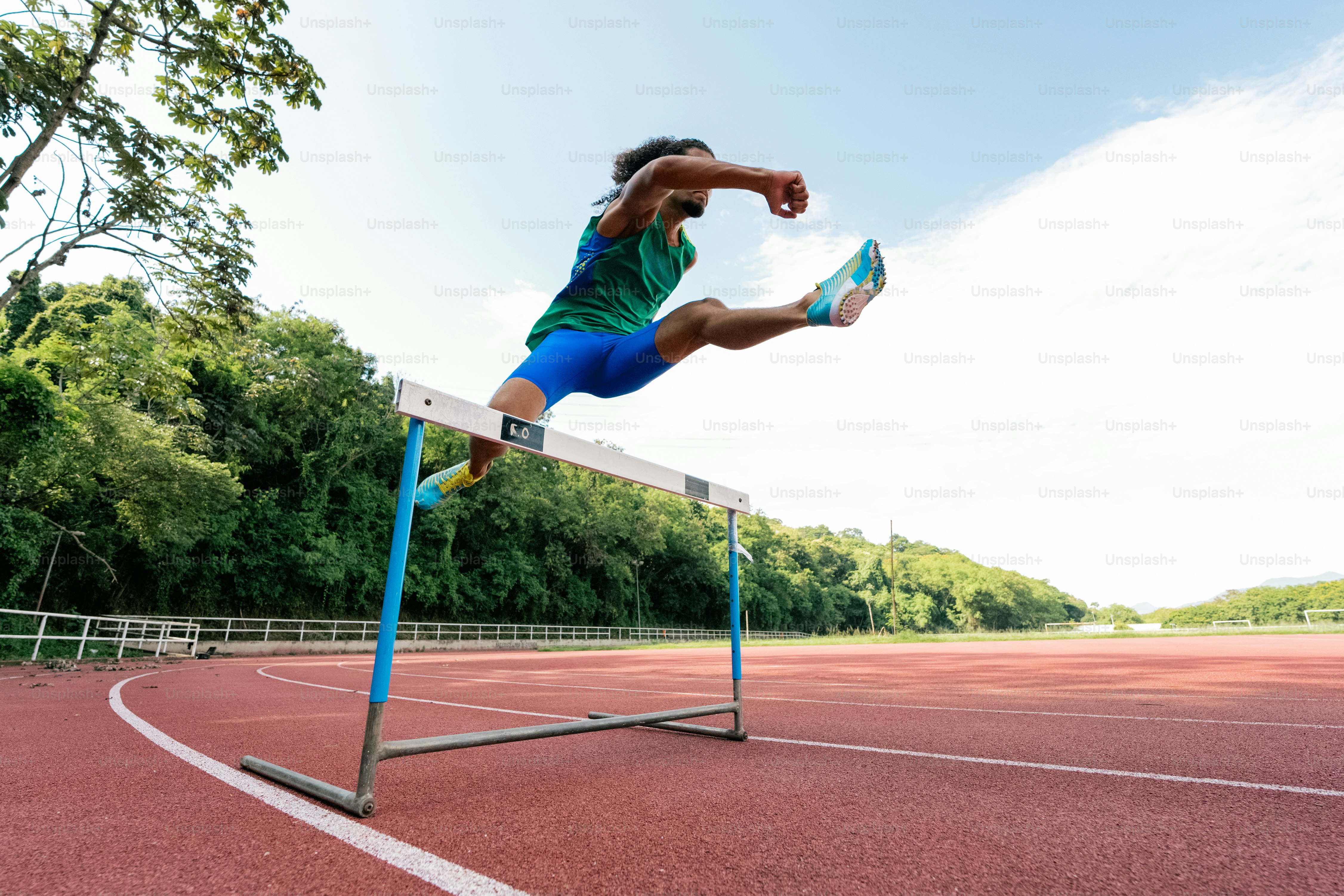A person jumping over a hurdle on a track