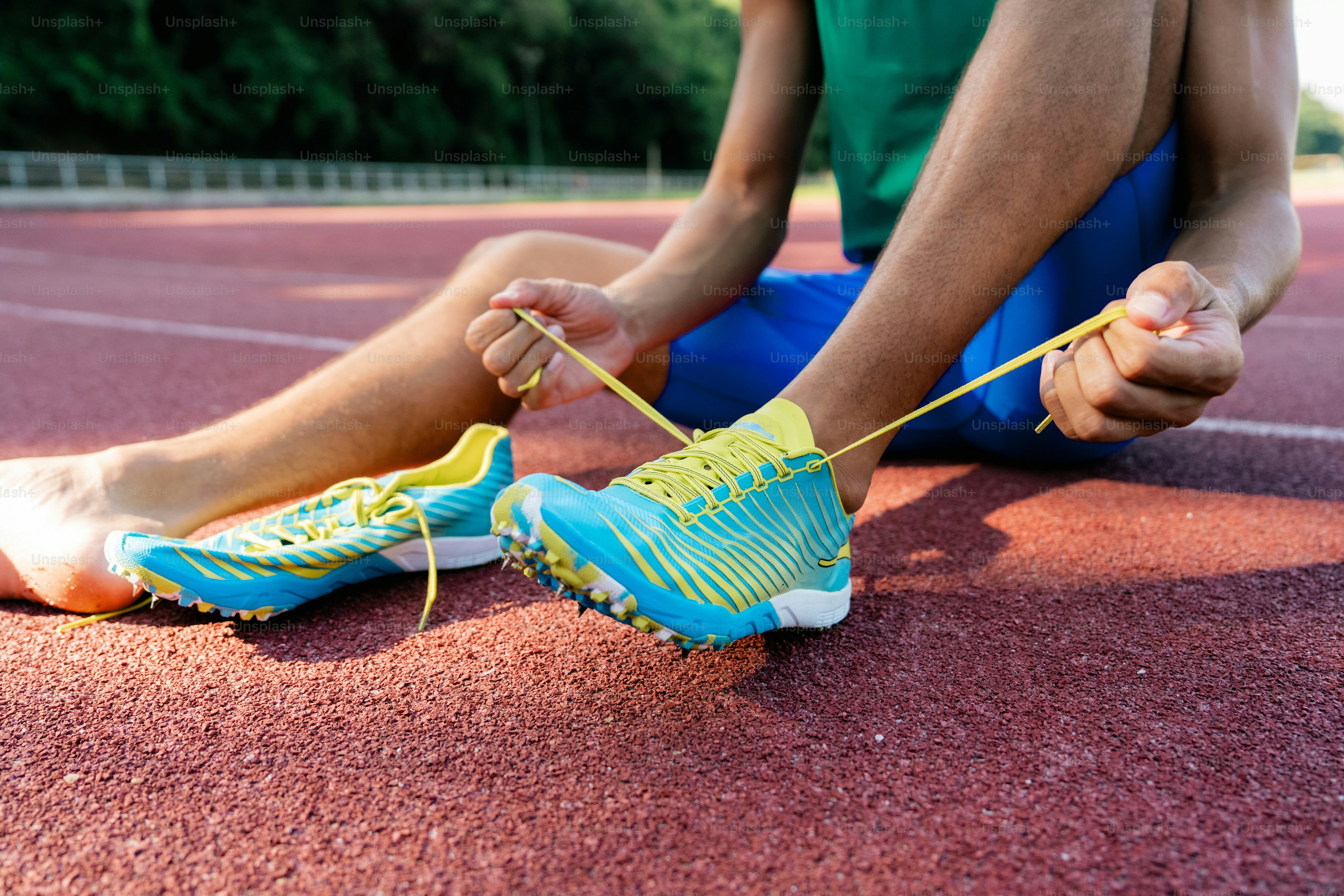 A person tying a shoelace on a tennis court