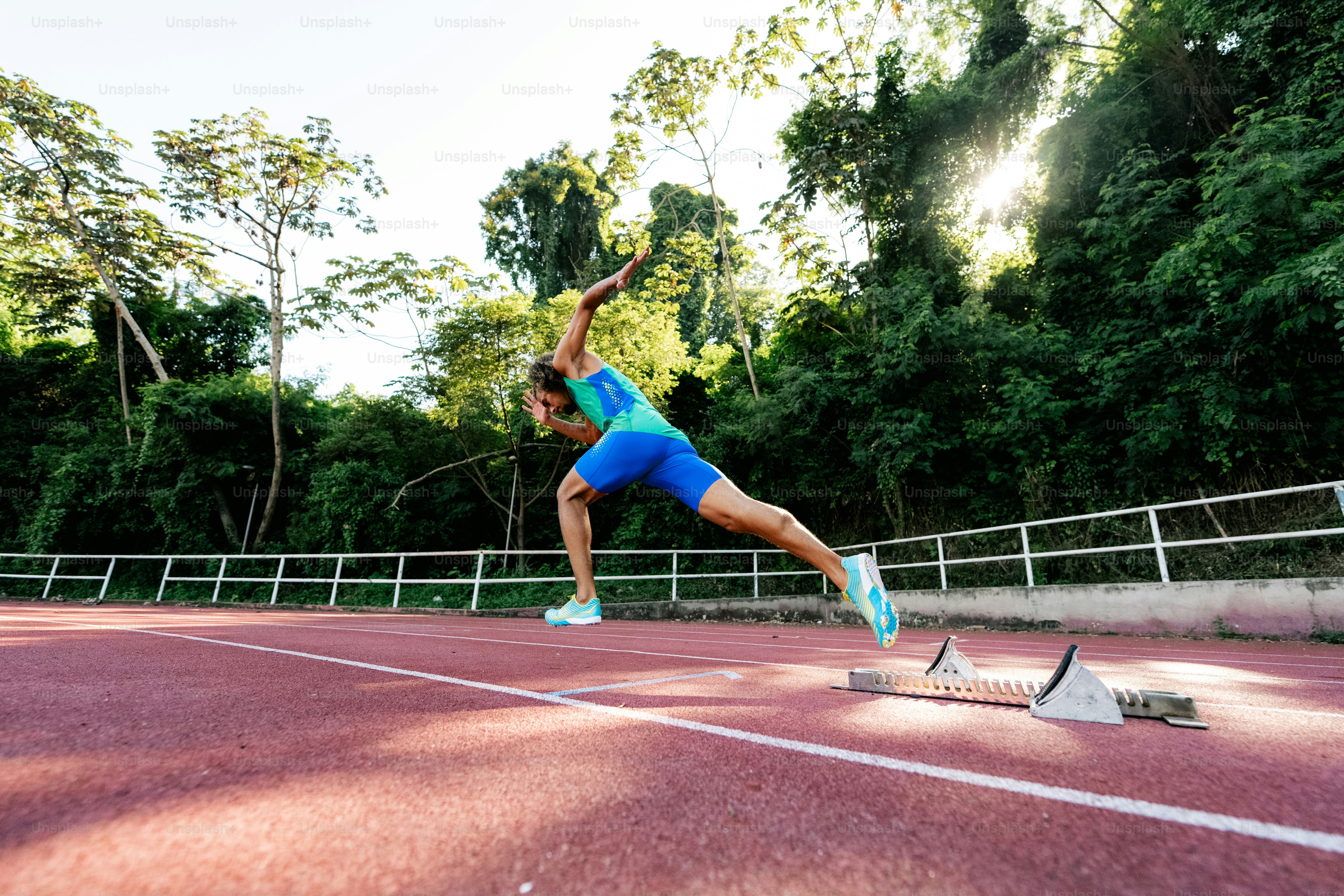 A woman running across a tennis court on a sunny day