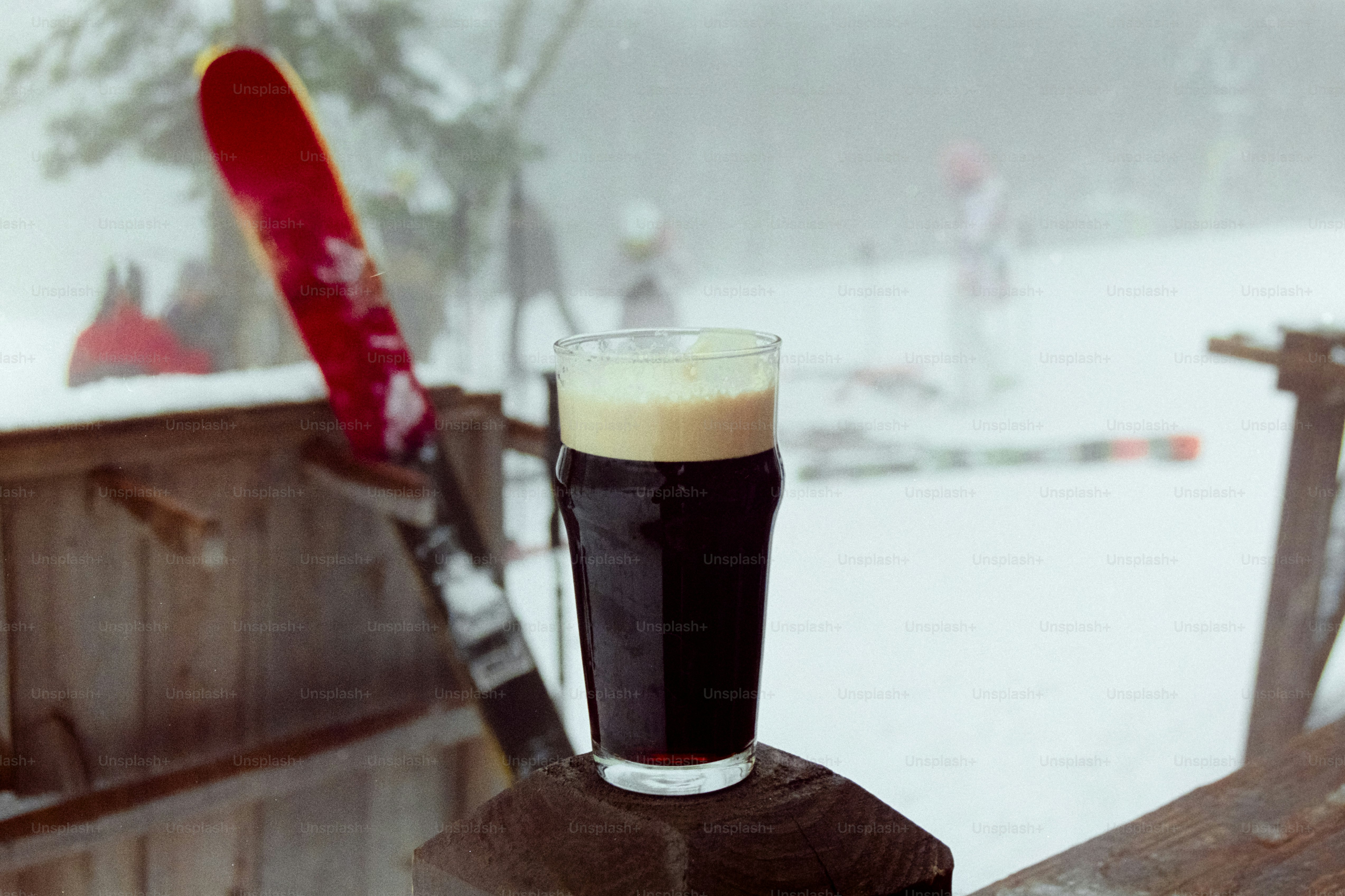 A glass of beer sitting on top of a wooden table