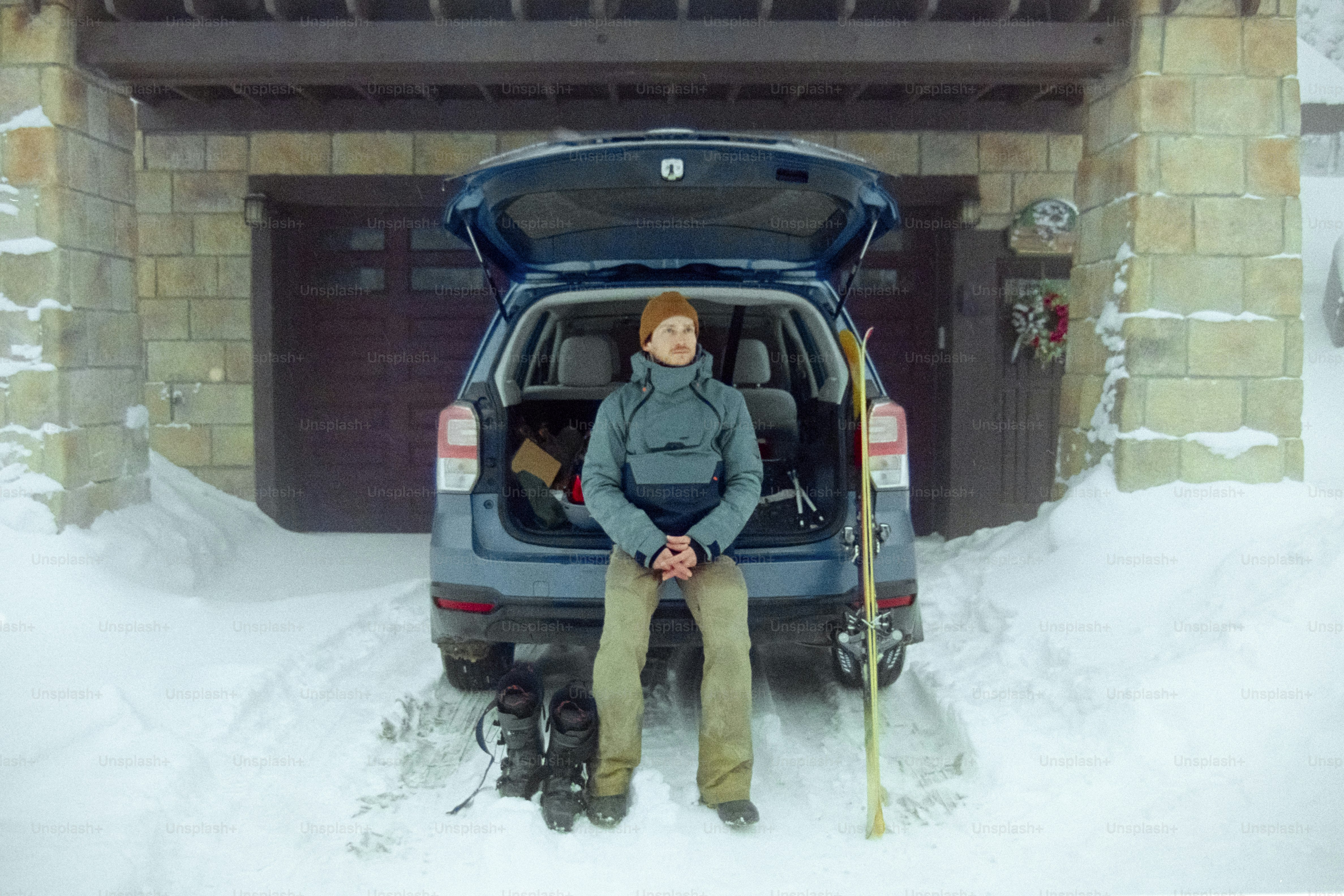 A man sitting in the back of a car in the snow