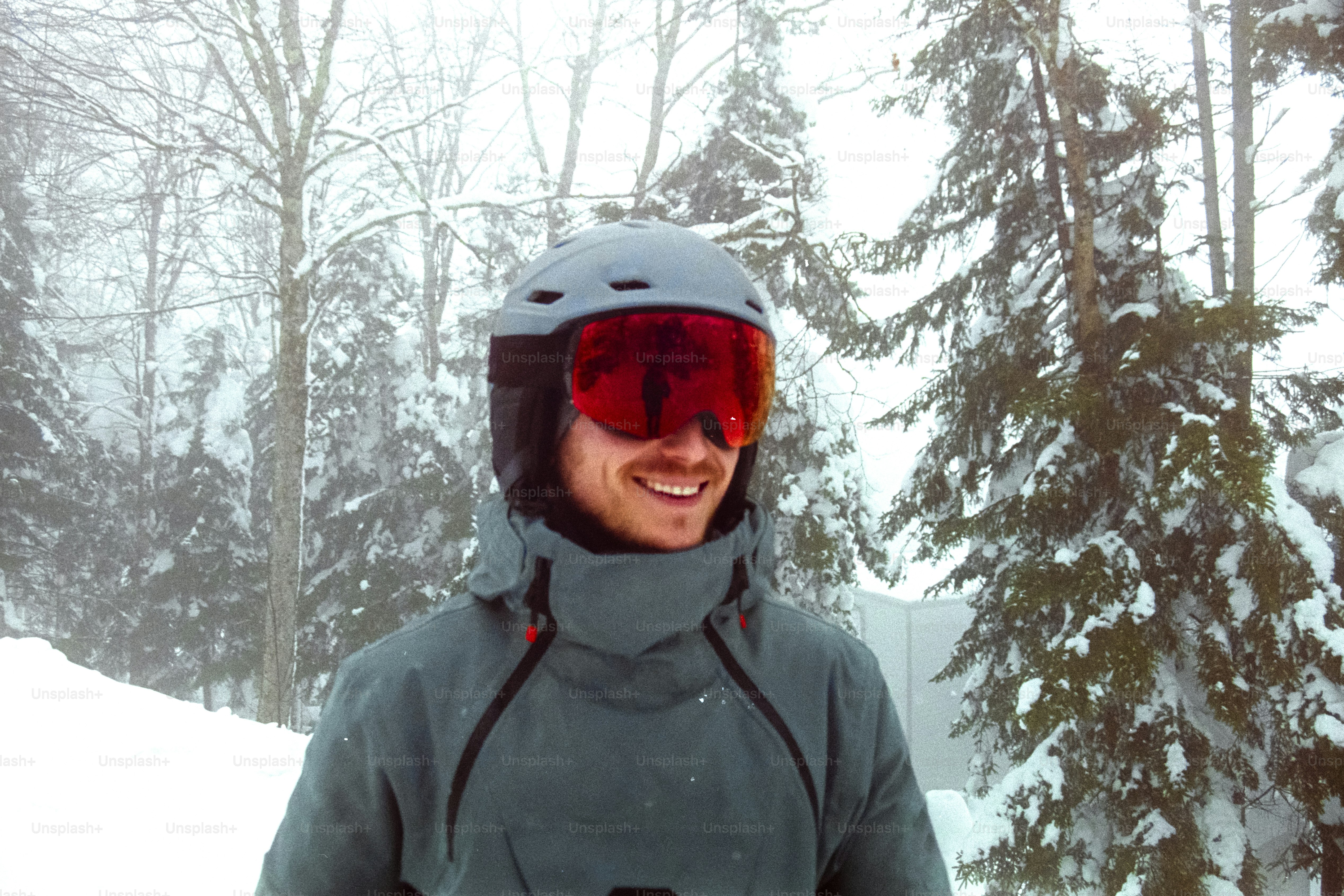 Un uomo in piedi nella neve che indossa un casco e occhiali