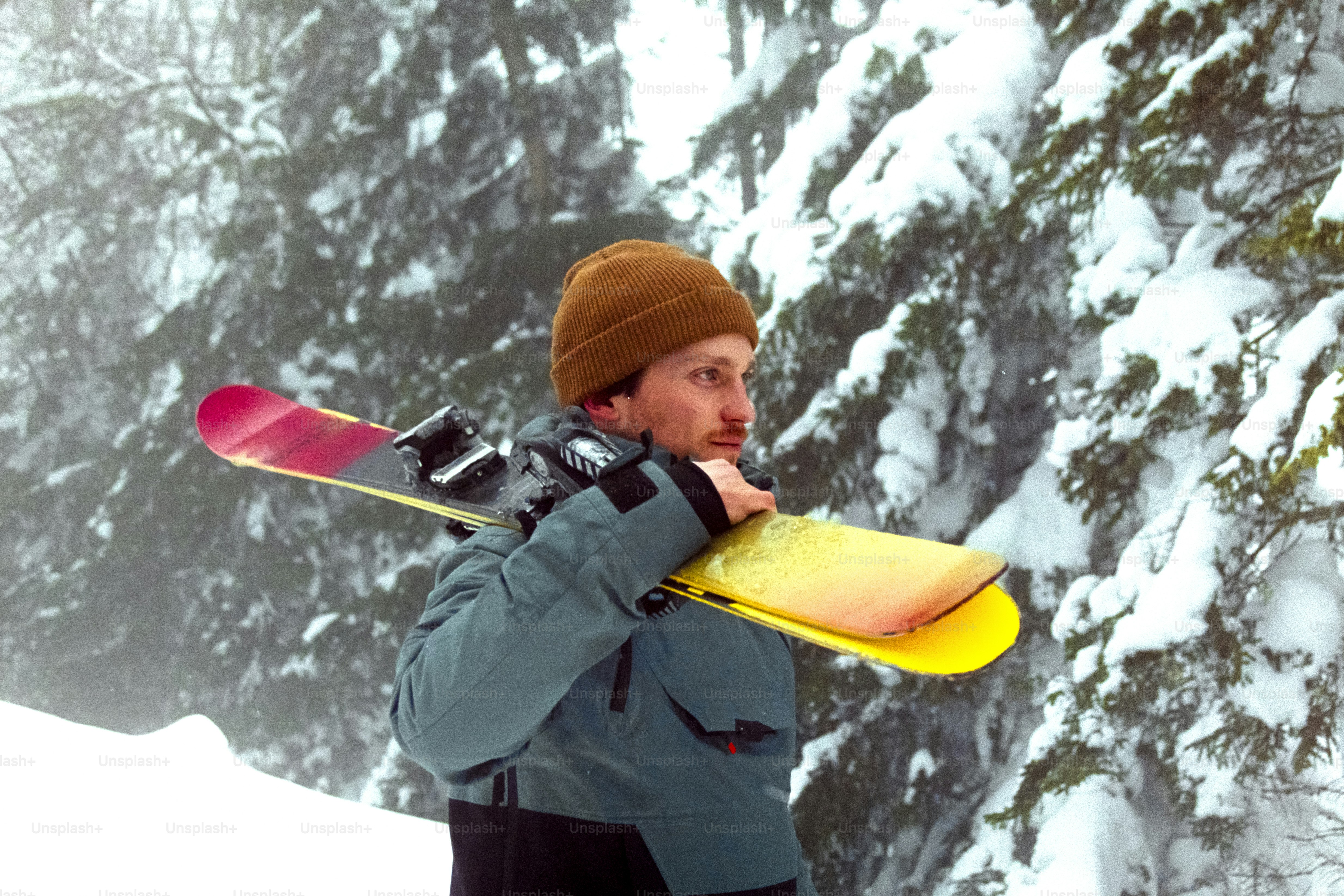 A man holding a snowboard while standing in the snow