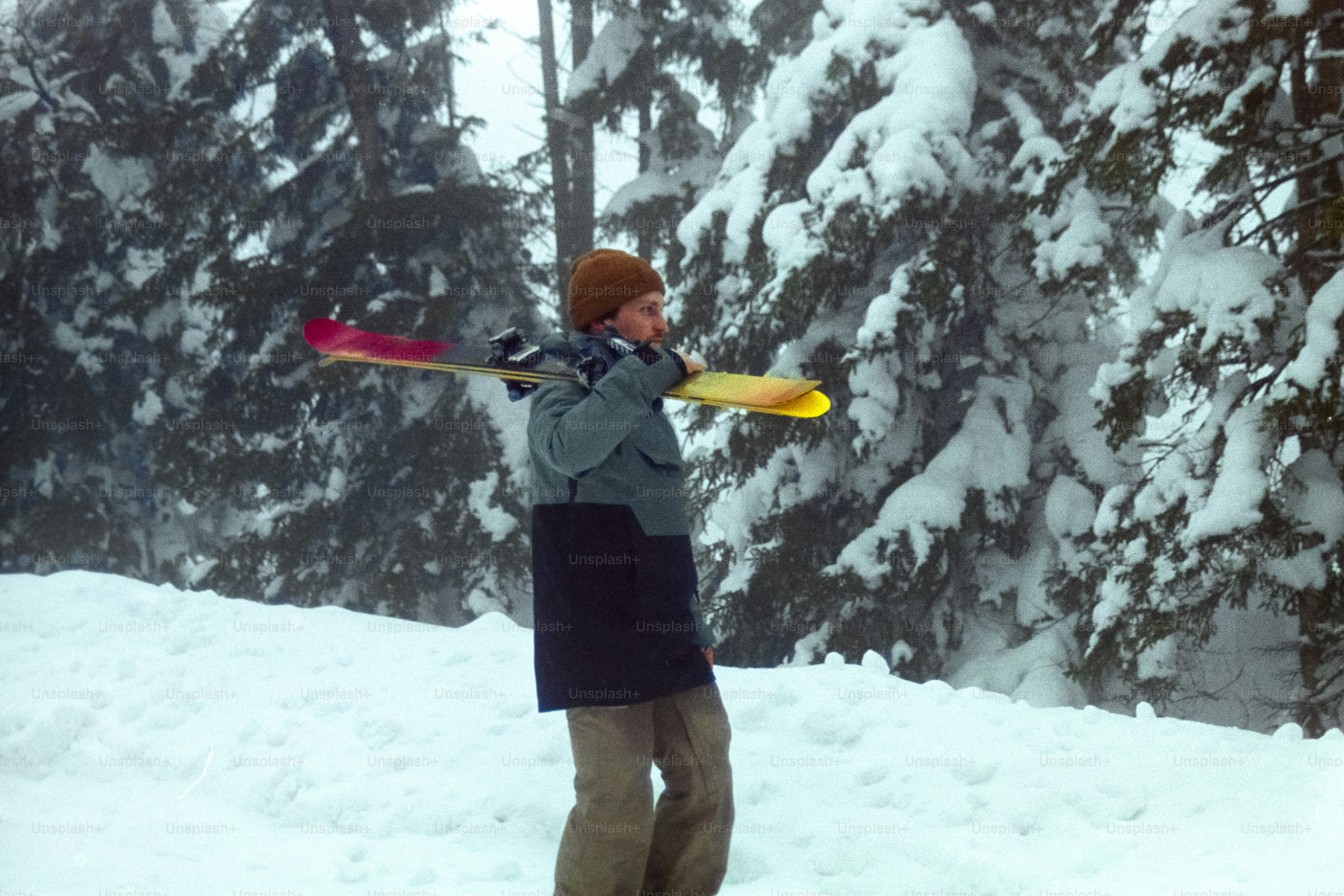 A man standing in the snow holding a snowboard