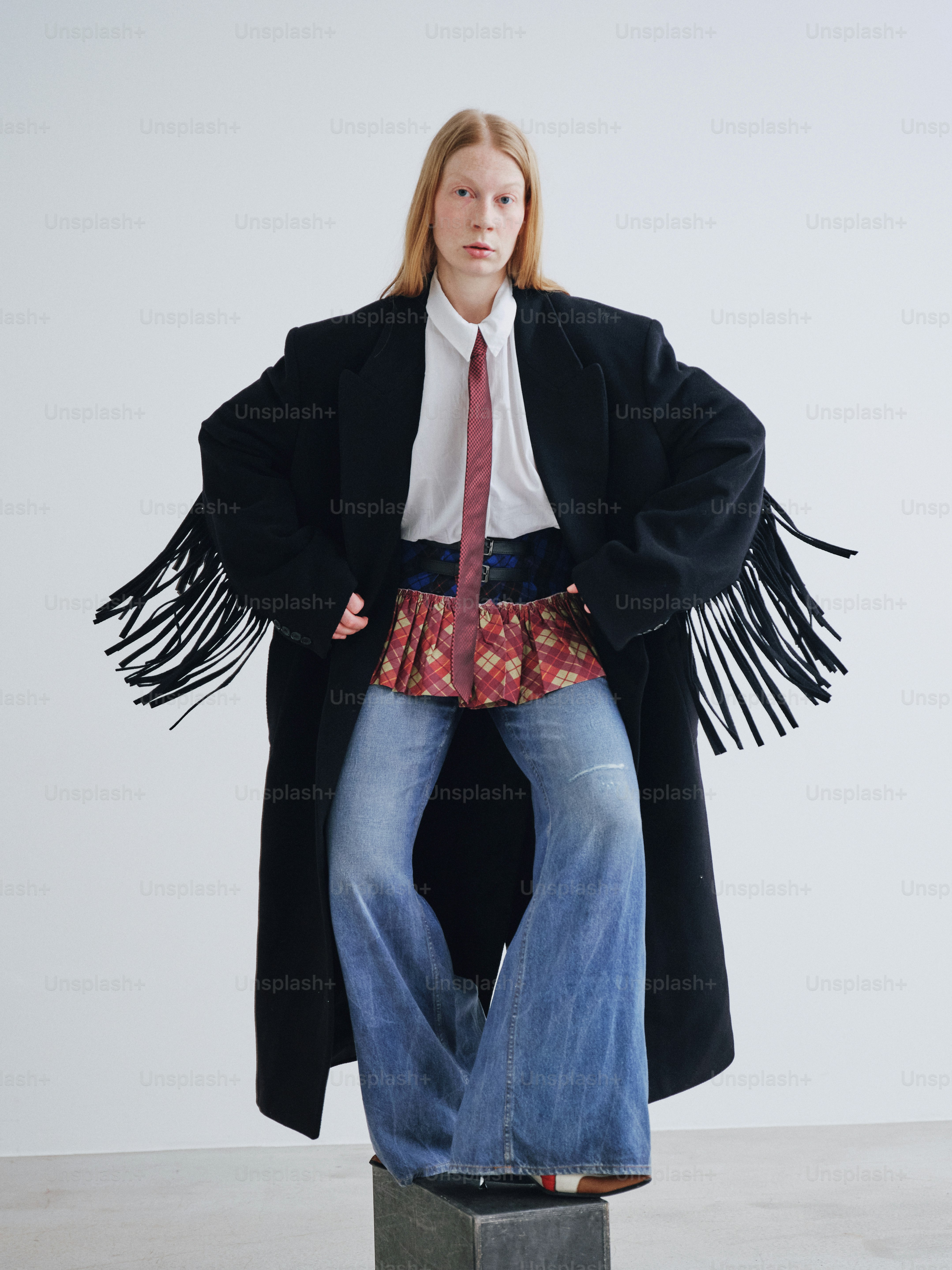 A woman in a black coat and a red tie