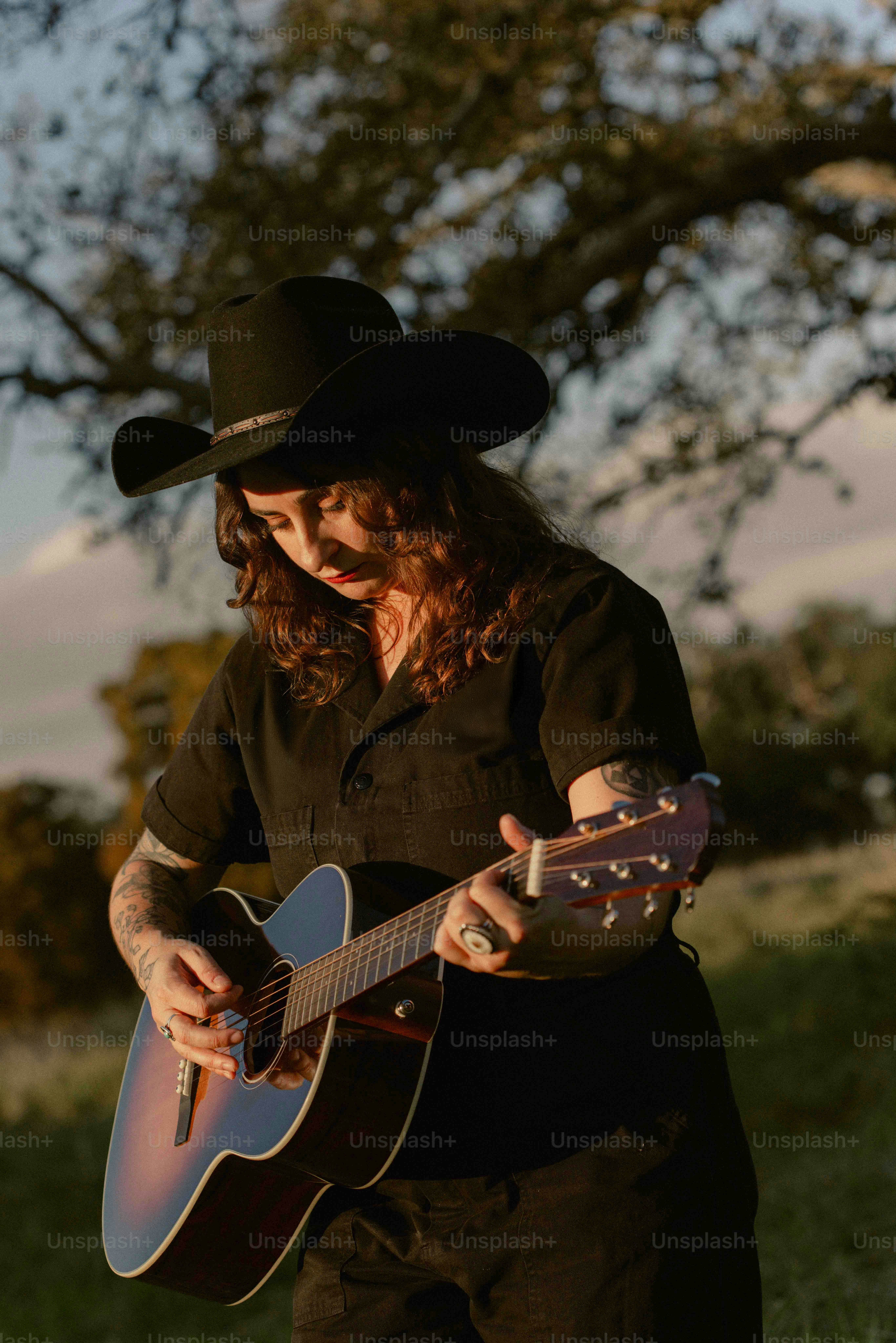 A man in a cowboy hat playing a guitar