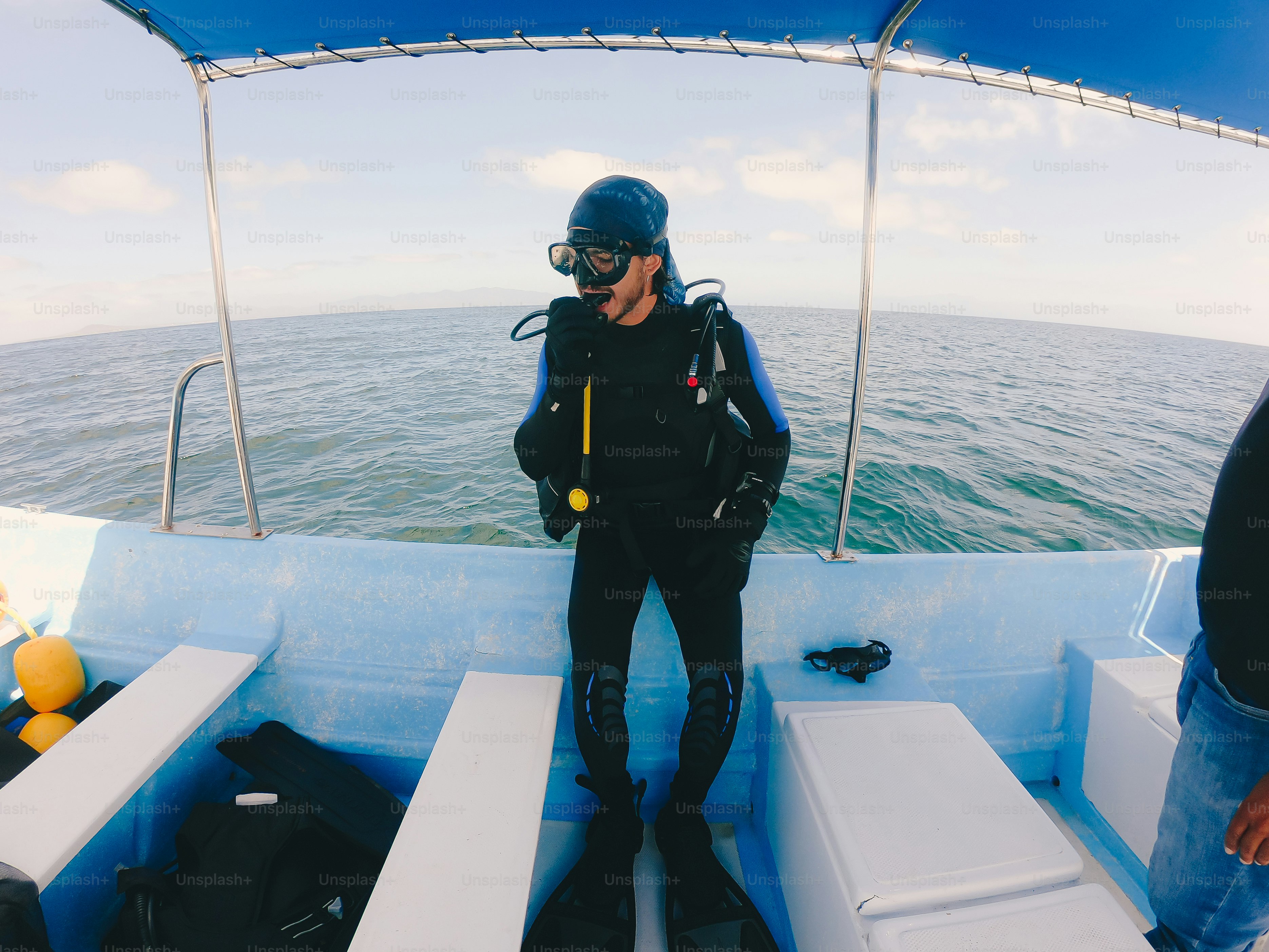 A man in a wet suit standing on a boat