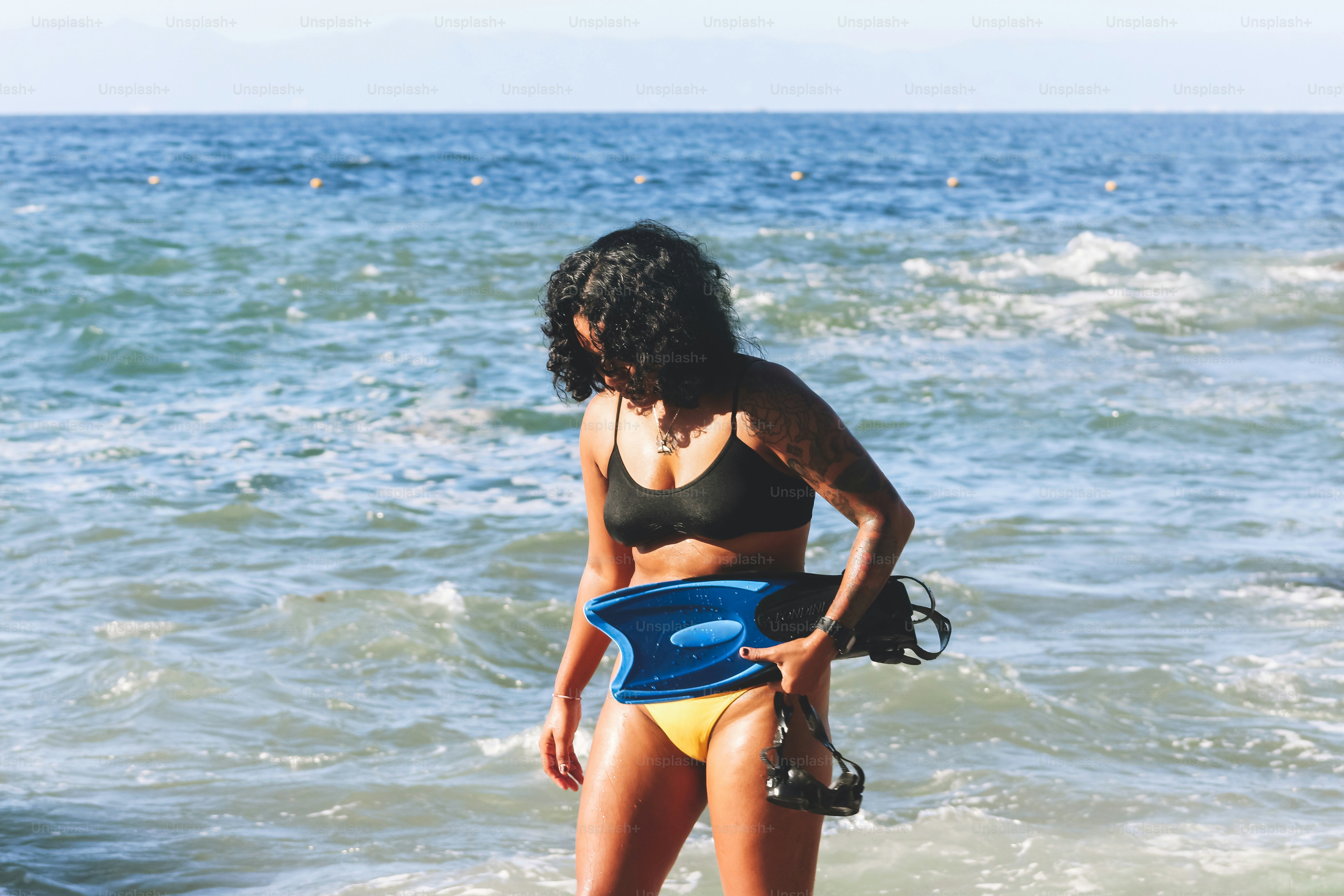 A woman in a bikini standing on a surfboard