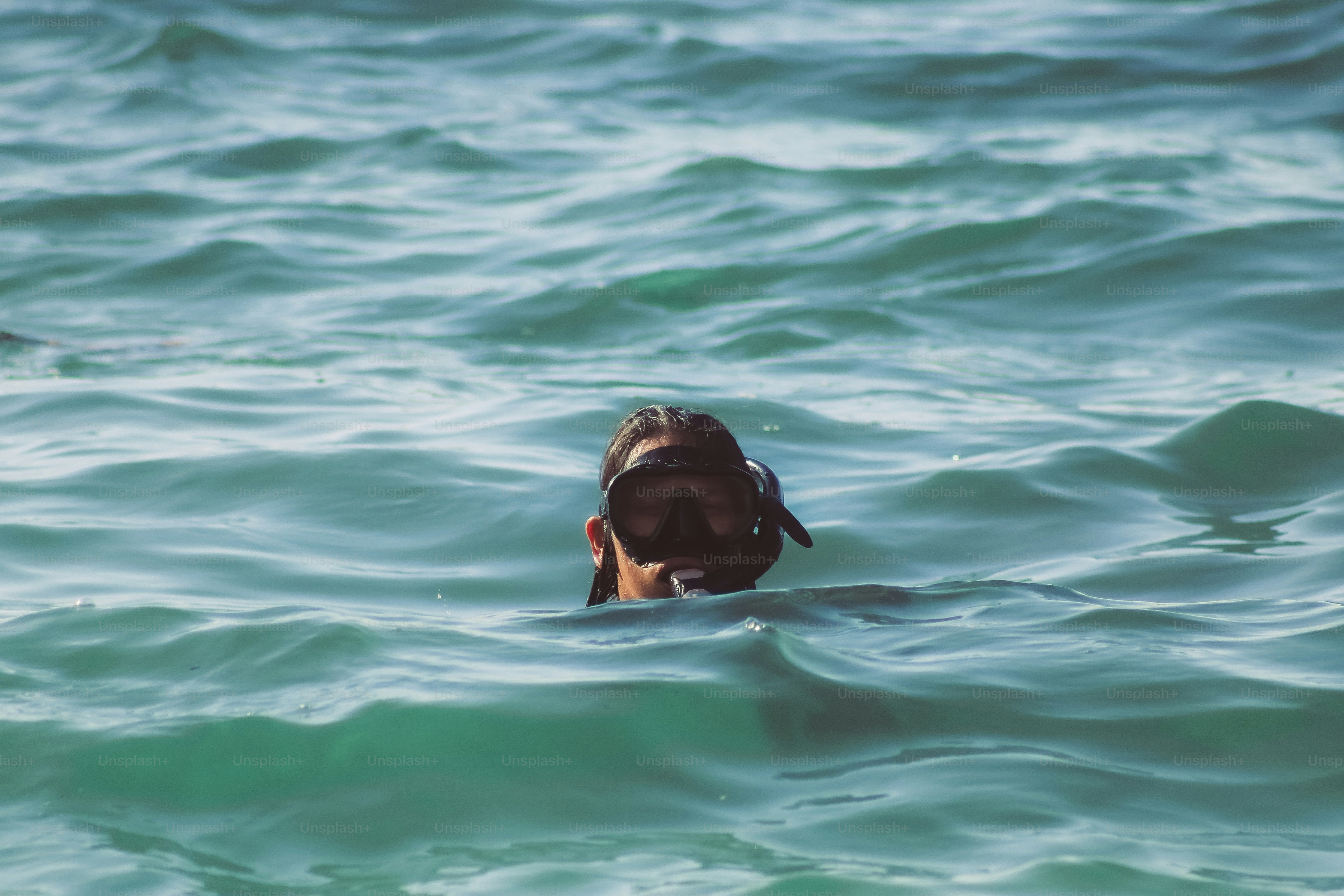 A person swimming in the ocean with their head above the water