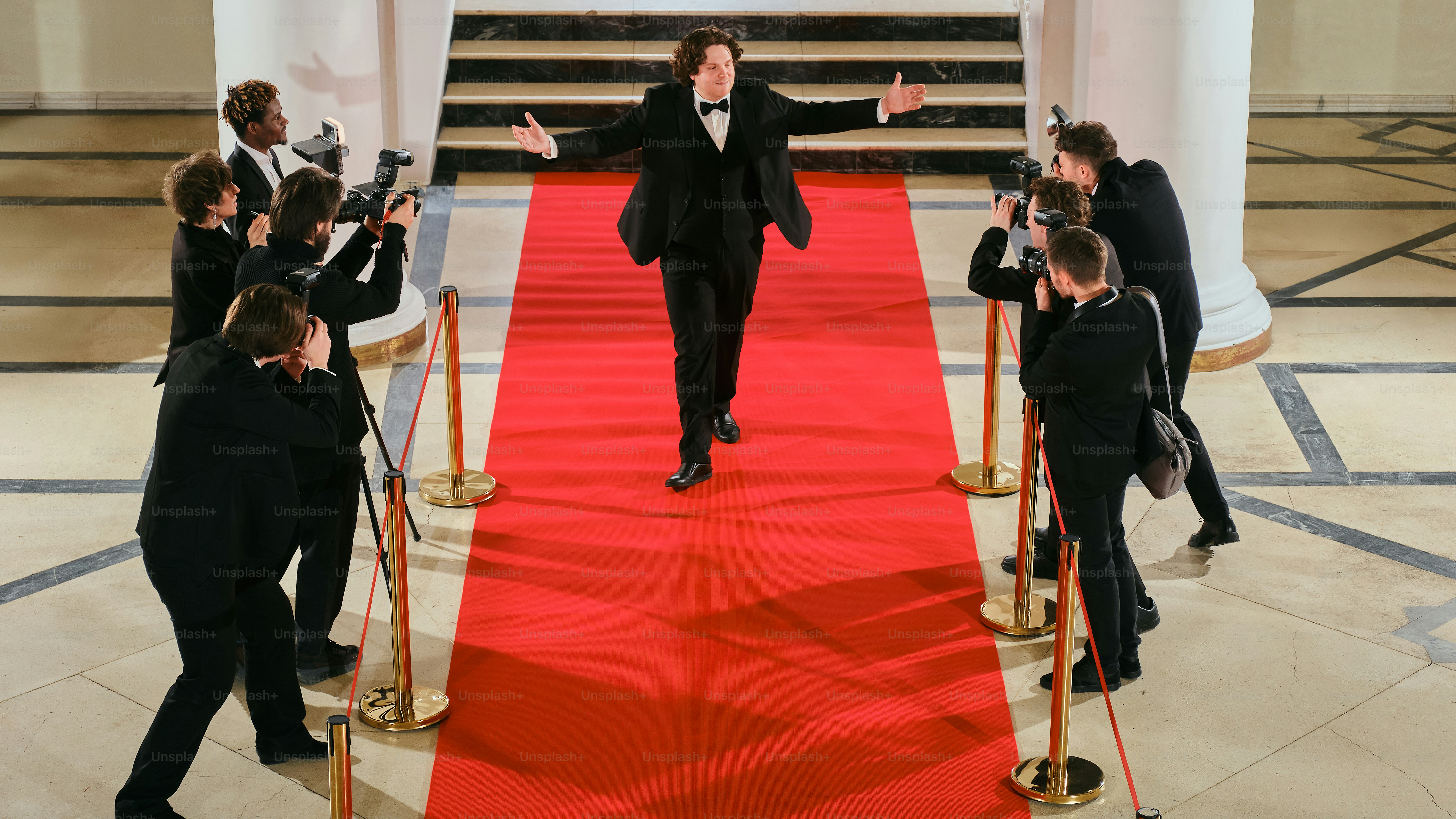 A man in a tuxedo walking down a red carpet