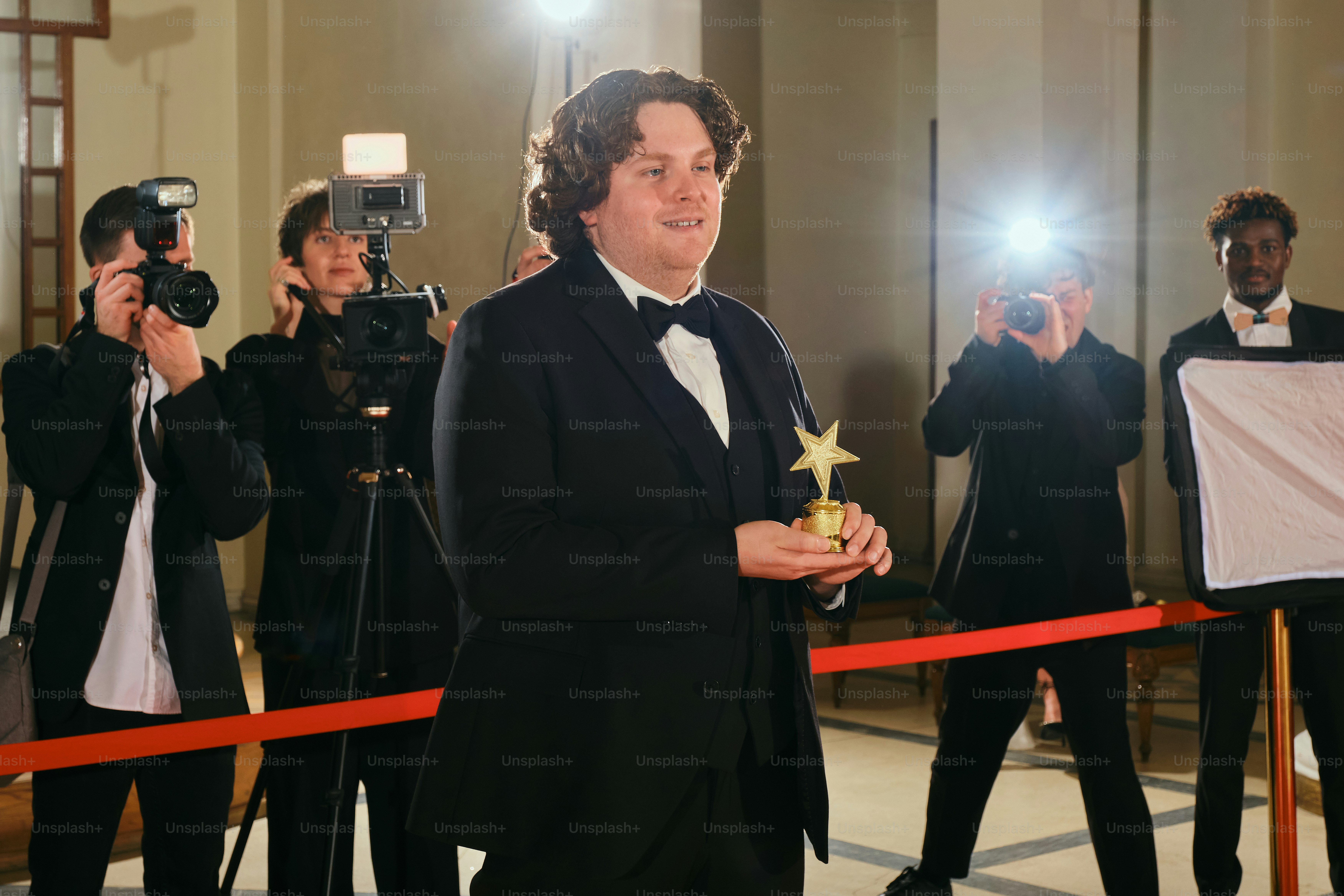 A man in a tuxedo holding a star