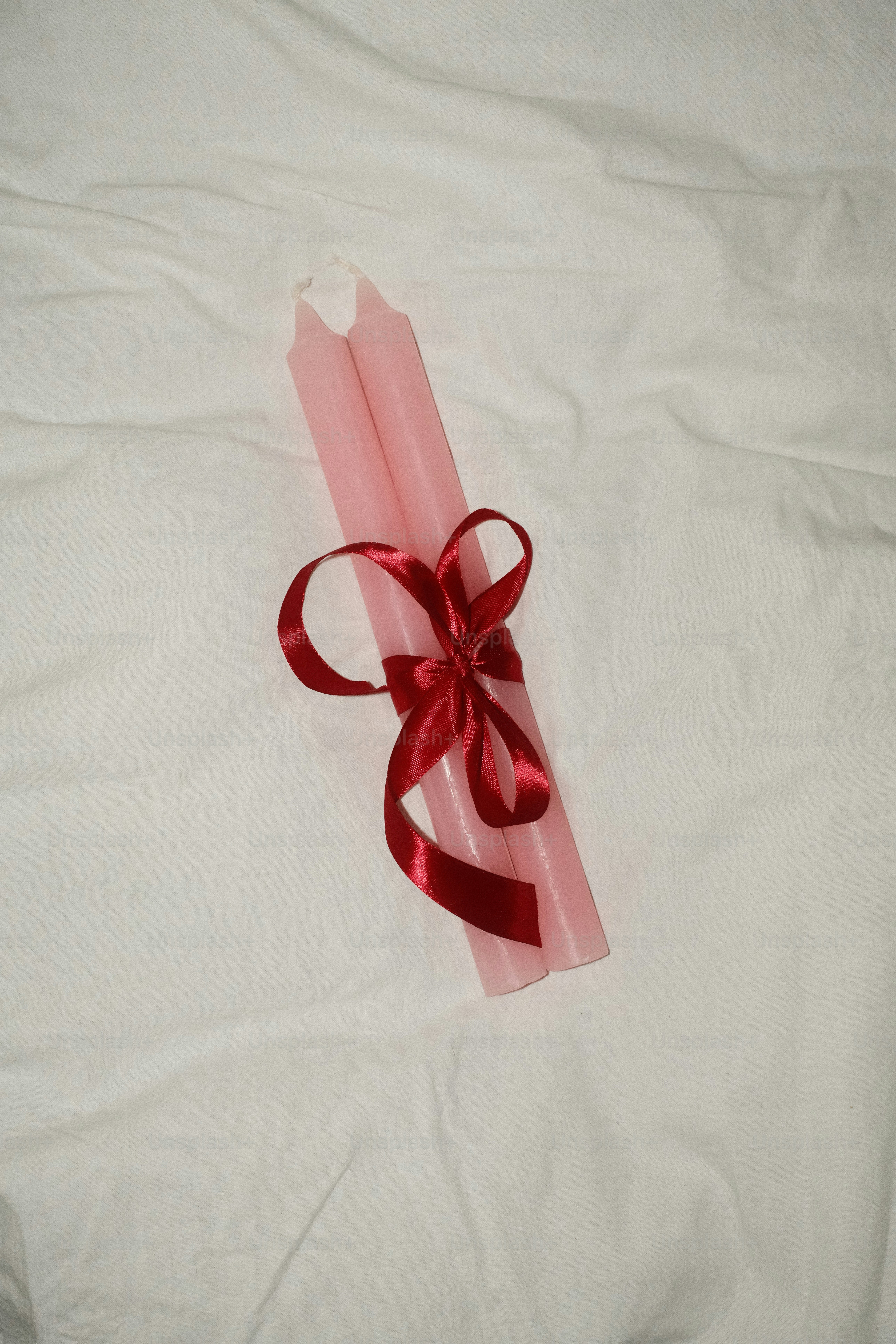 A red ribbon on a white sheet with a red bow