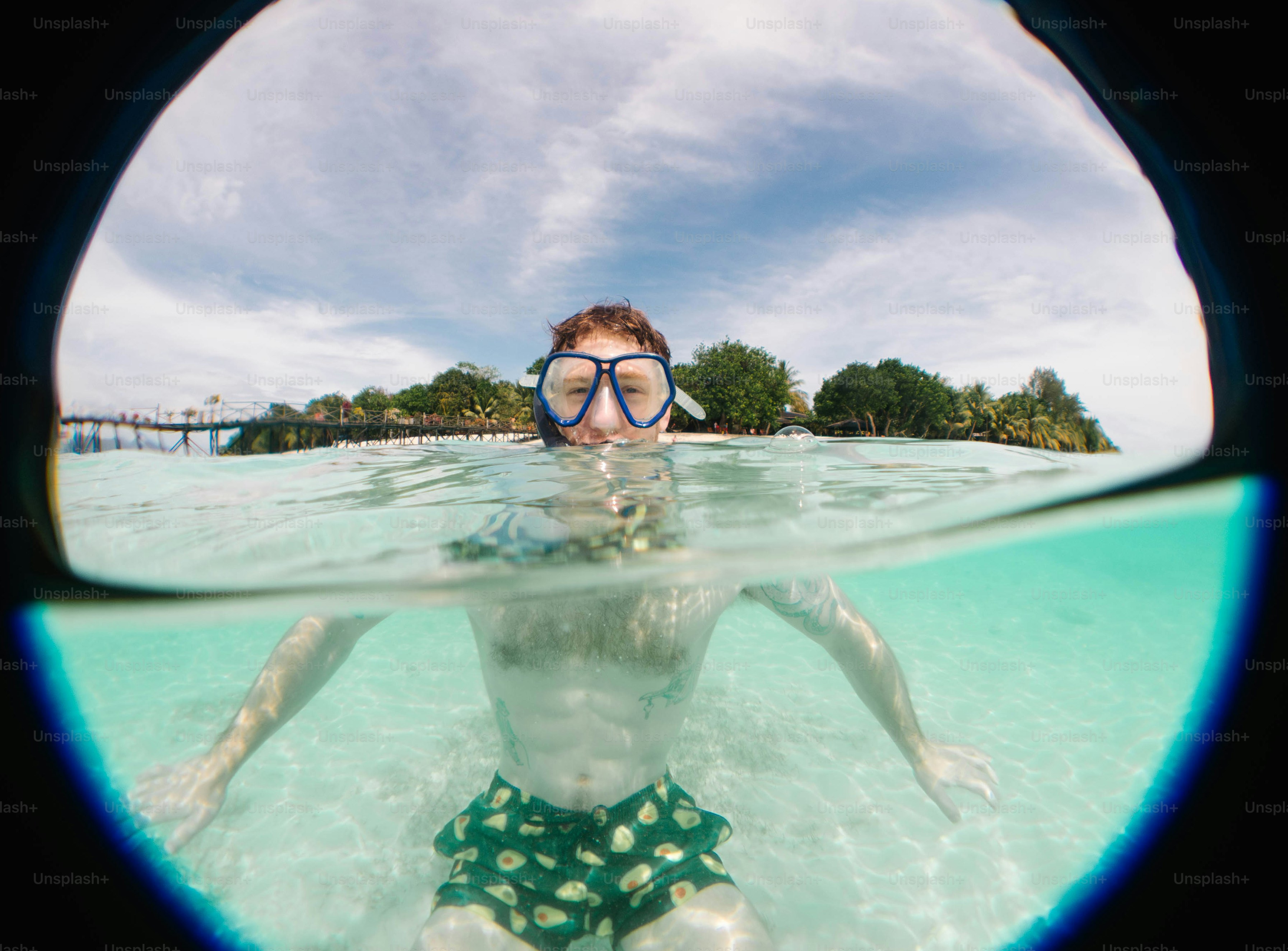 A man is swimming in the water with a mask on