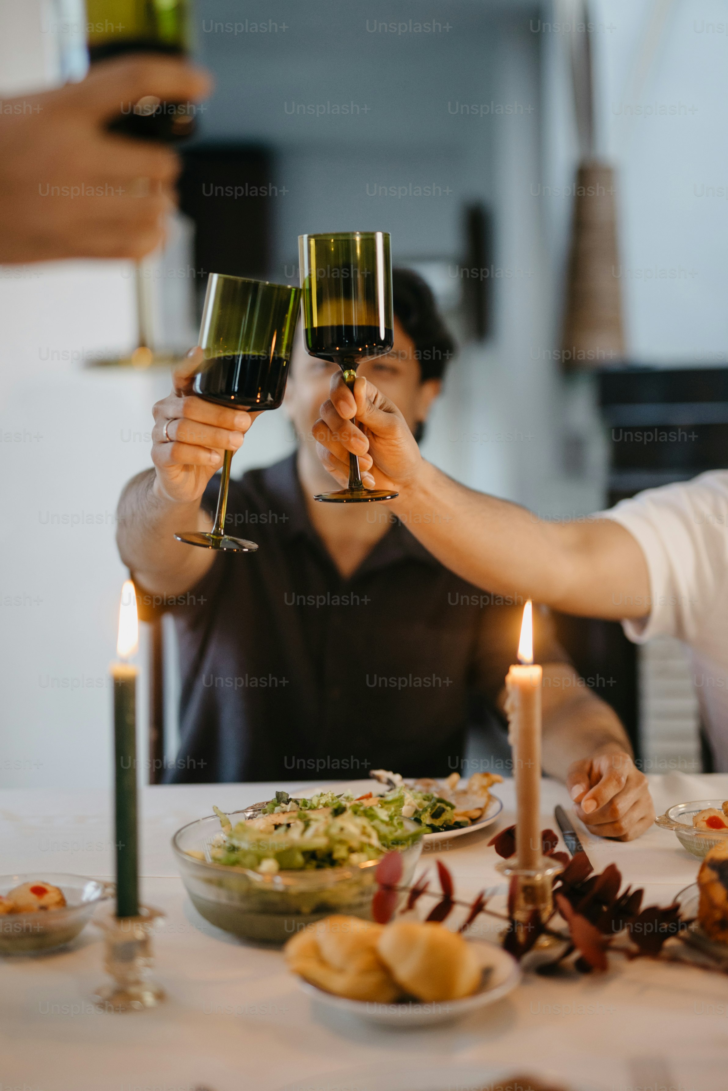 A group of people toasting wine glasses over a dinner table