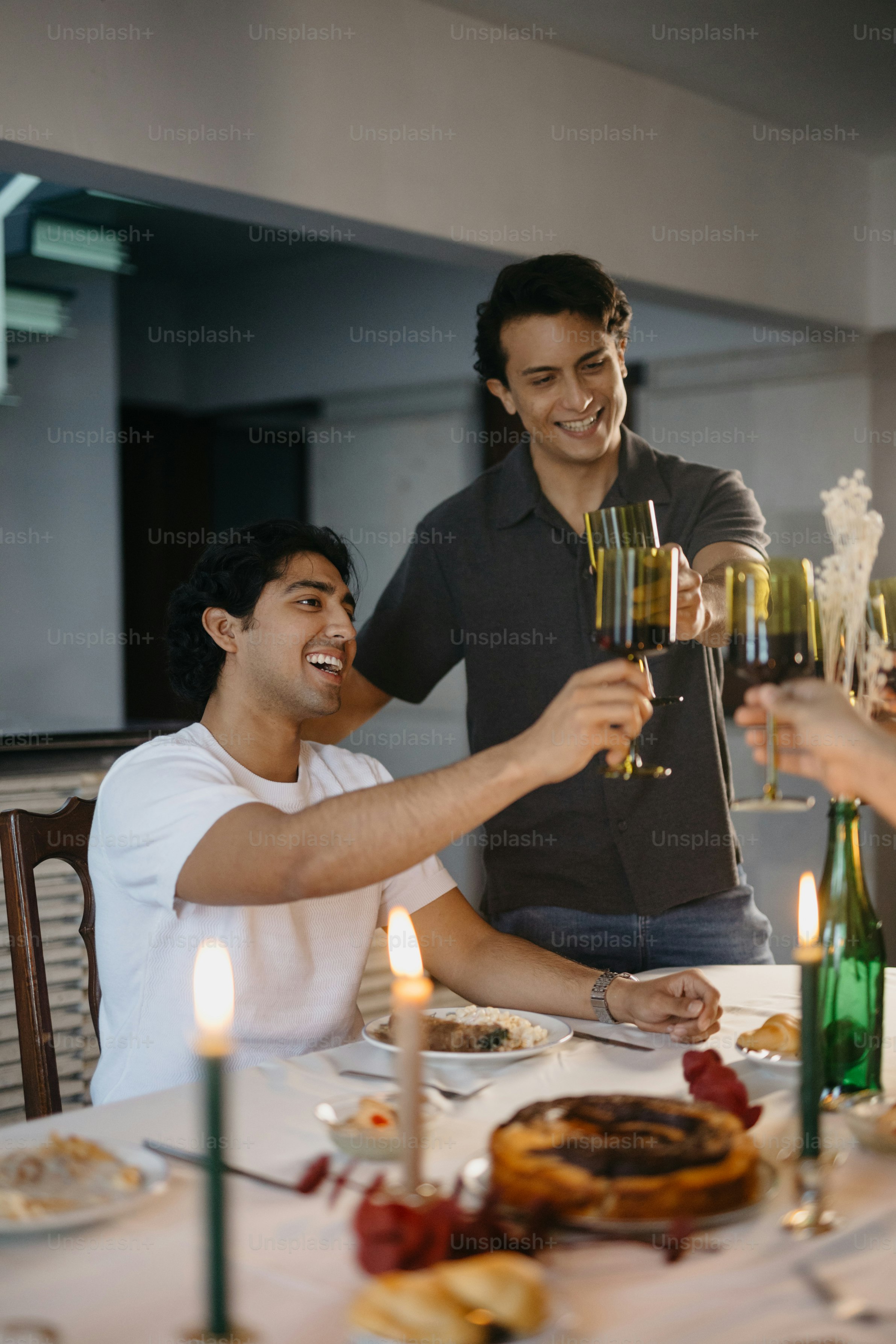 A group of people sitting around a table with wine glasses photo – Food ...