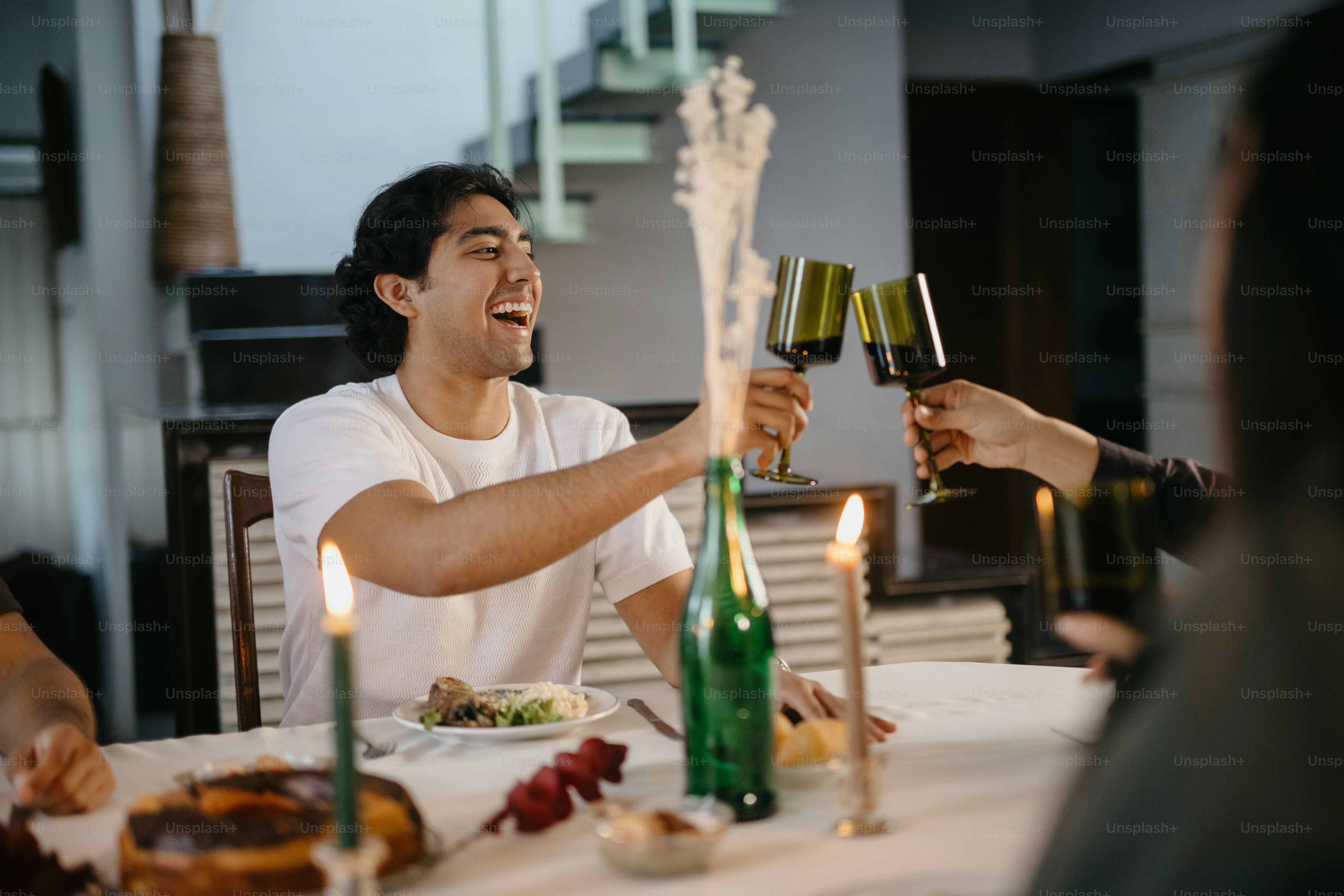 A group of people sitting around a table with wine glasses photo – Food ...