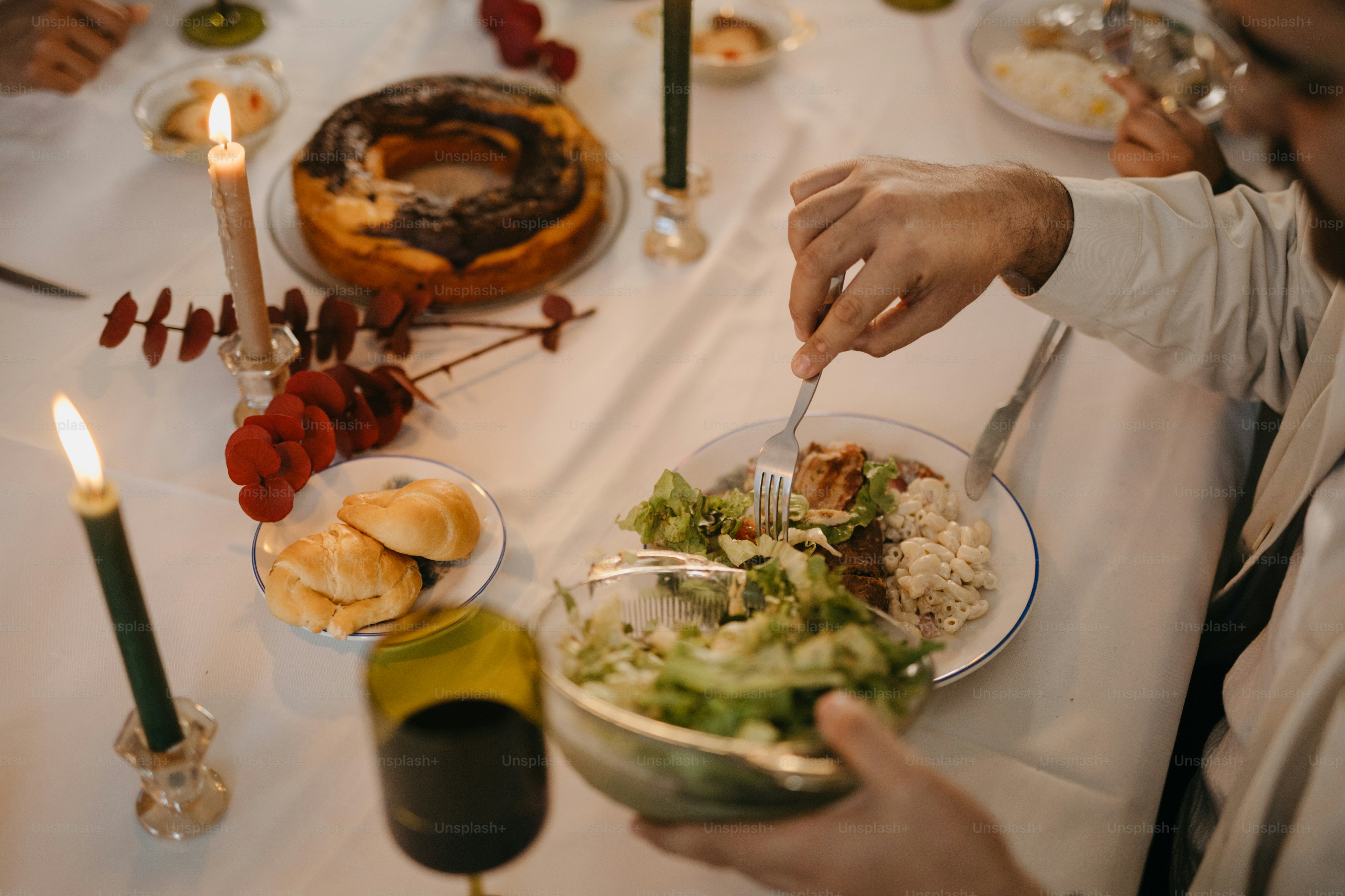 A man holding a plate of food at a dinner table