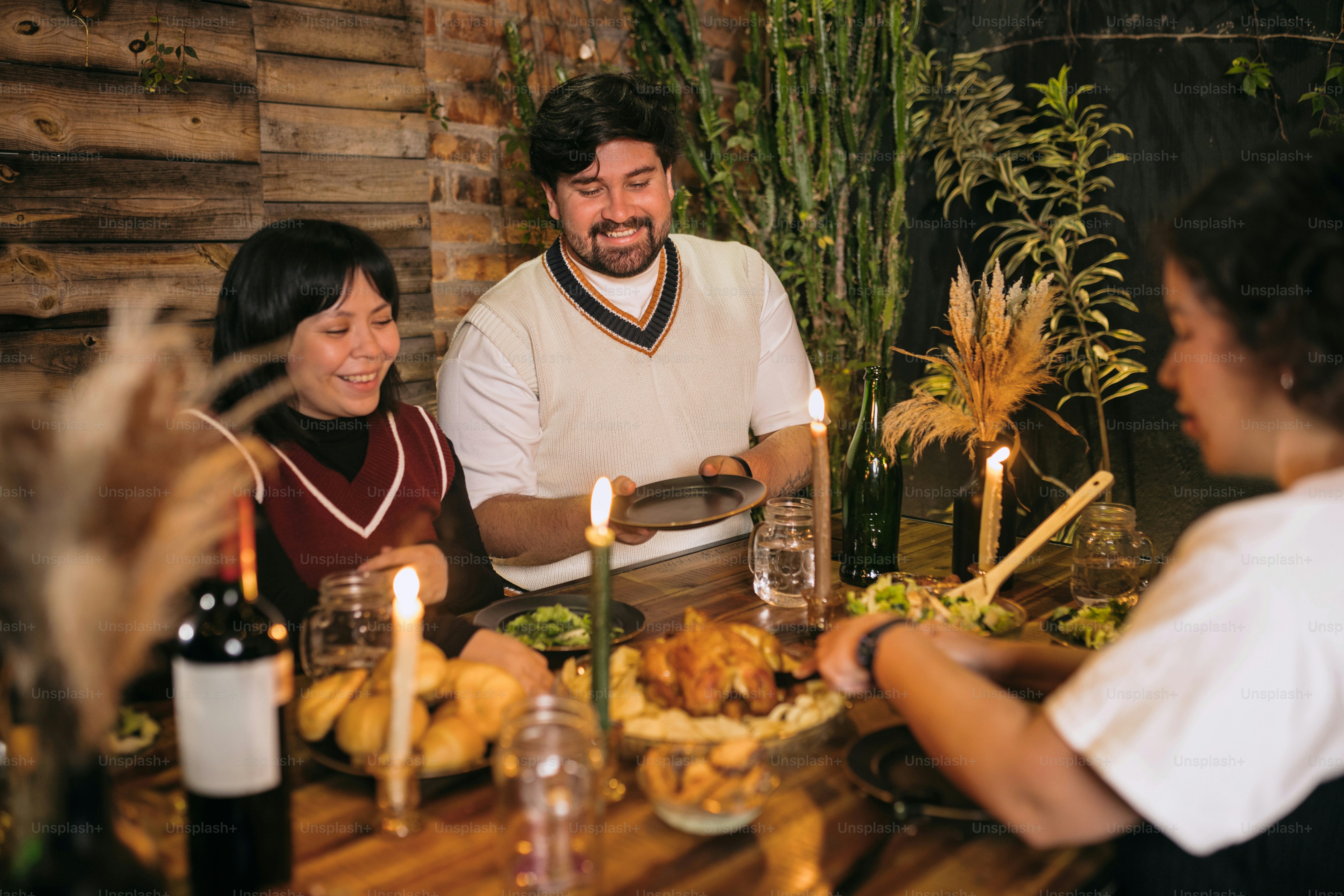 A group of people sitting around a table with food photo – Food Image ...