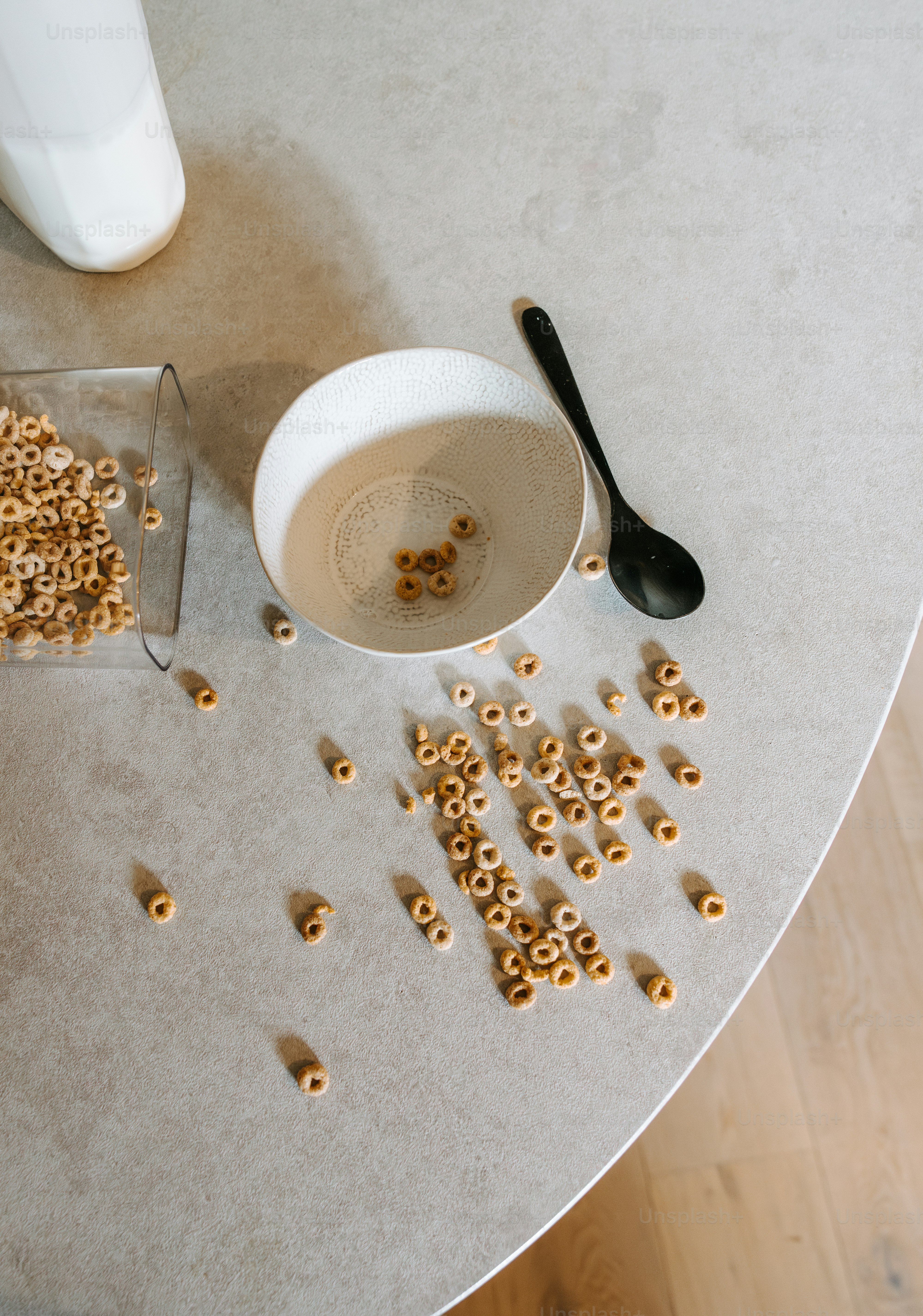 A bowl of cereal and a cup of milk on a table