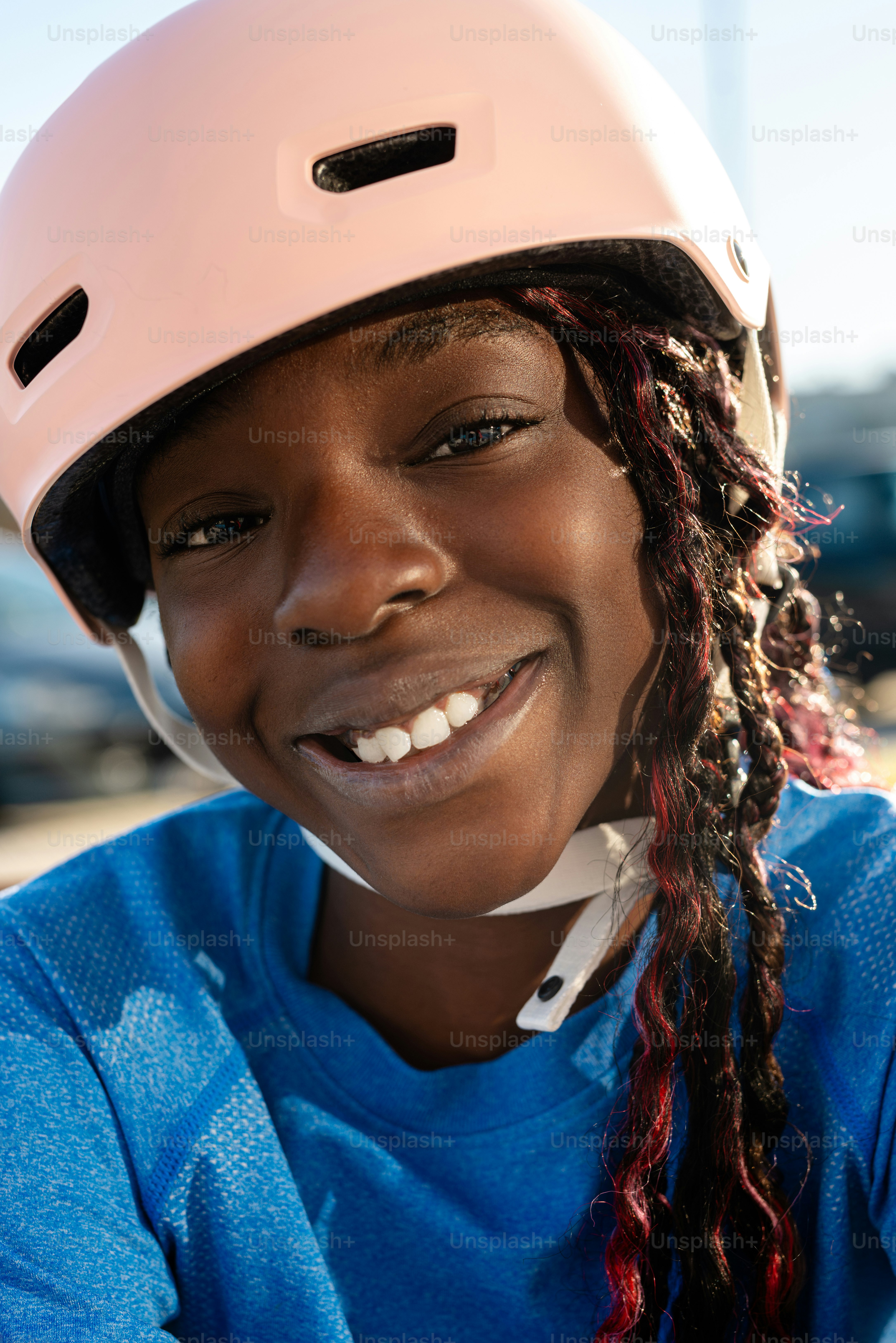 A young girl wearing a helmet and smiling