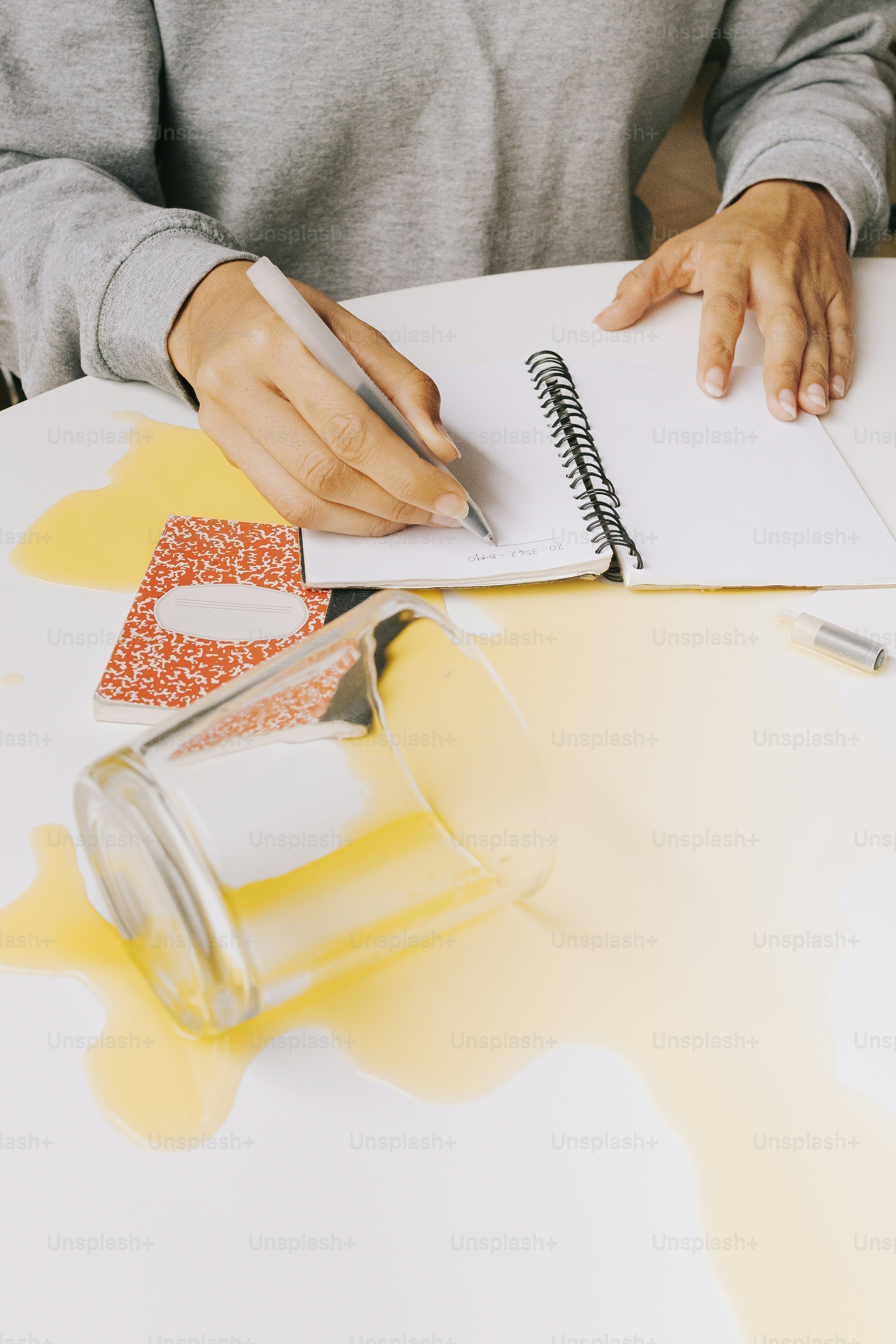 A person sitting at a table writing on a piece of paper