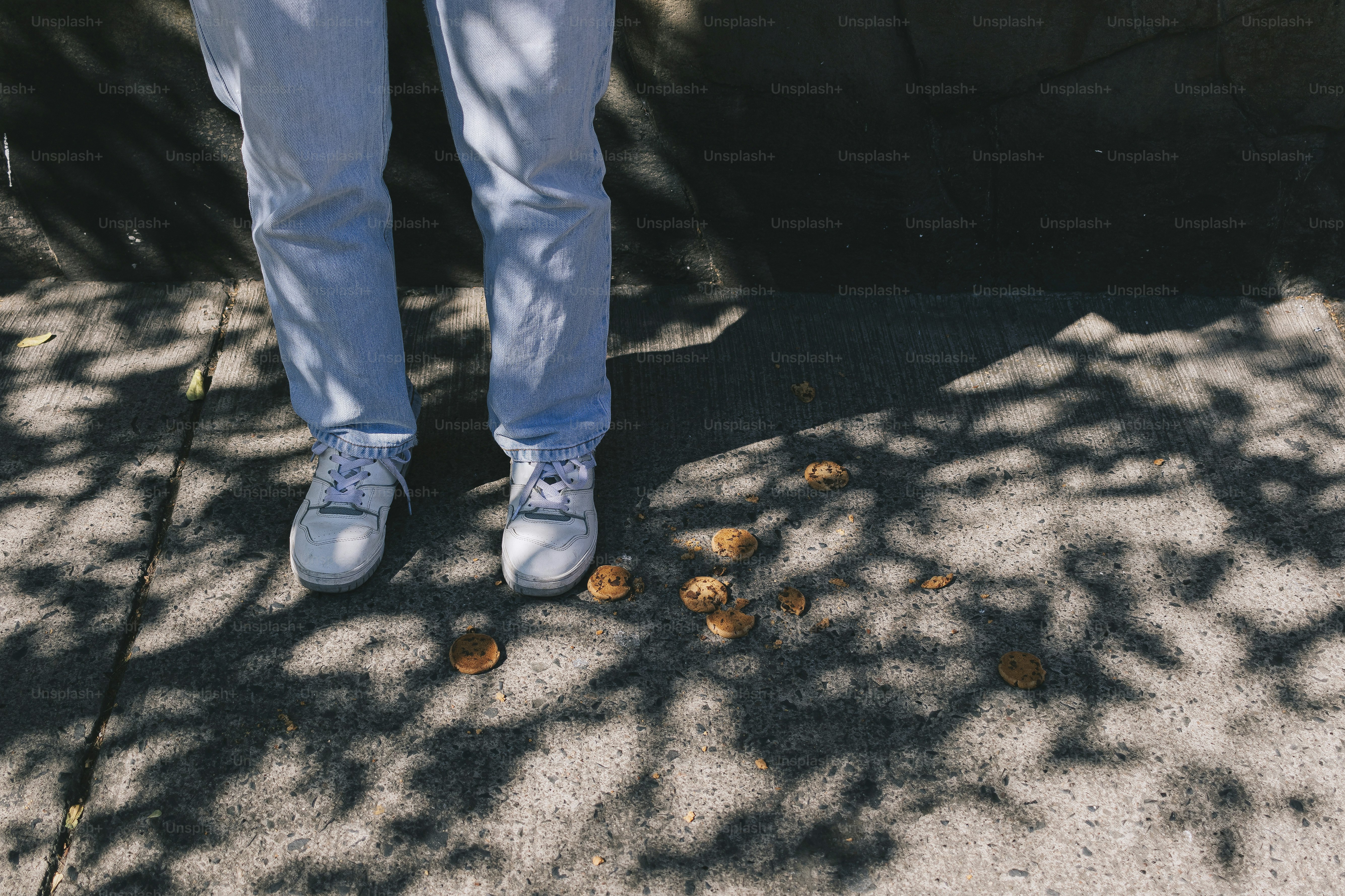 A man standing on a sidewalk with his hands in his pockets