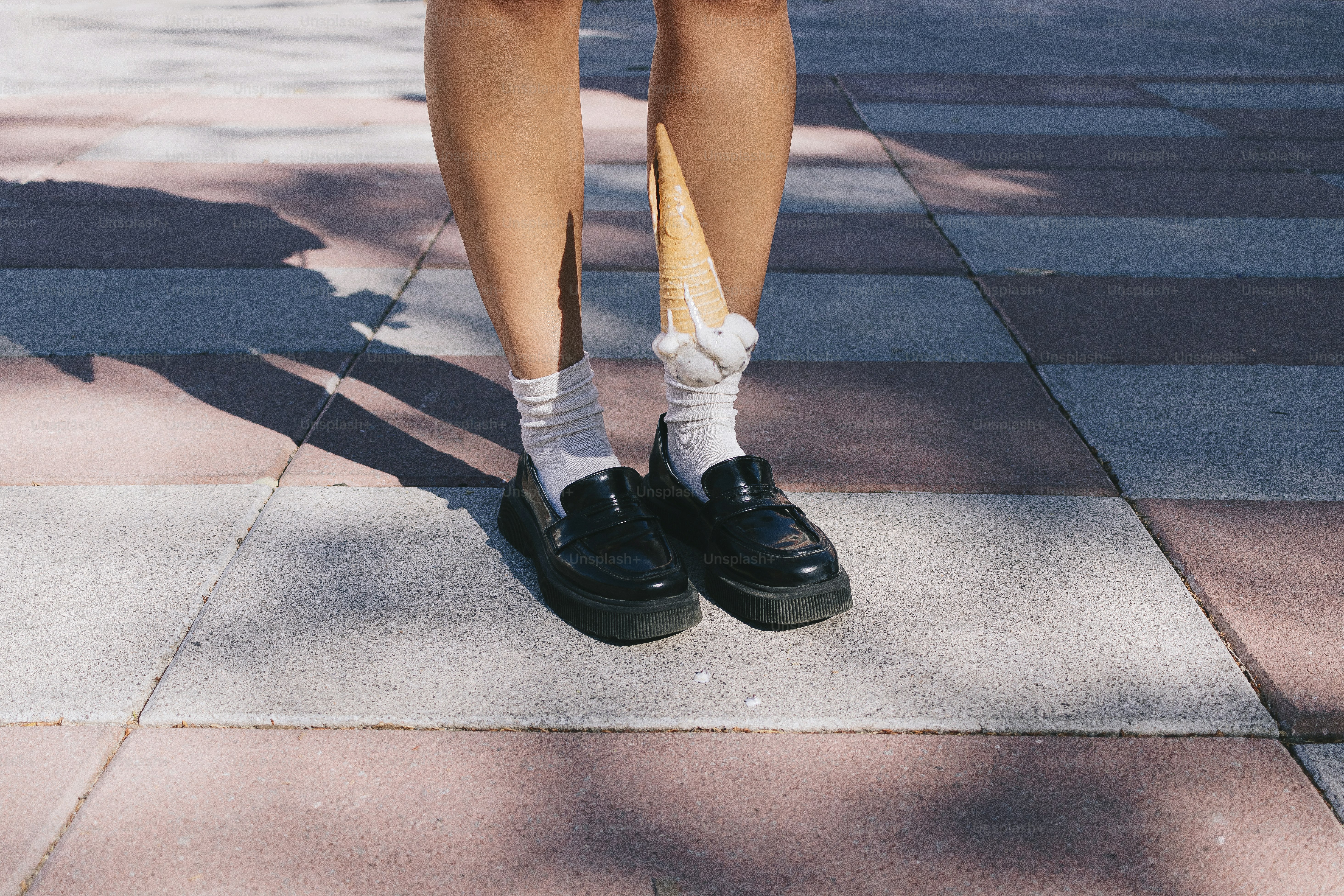 A person wearing black shoes and a white shirt