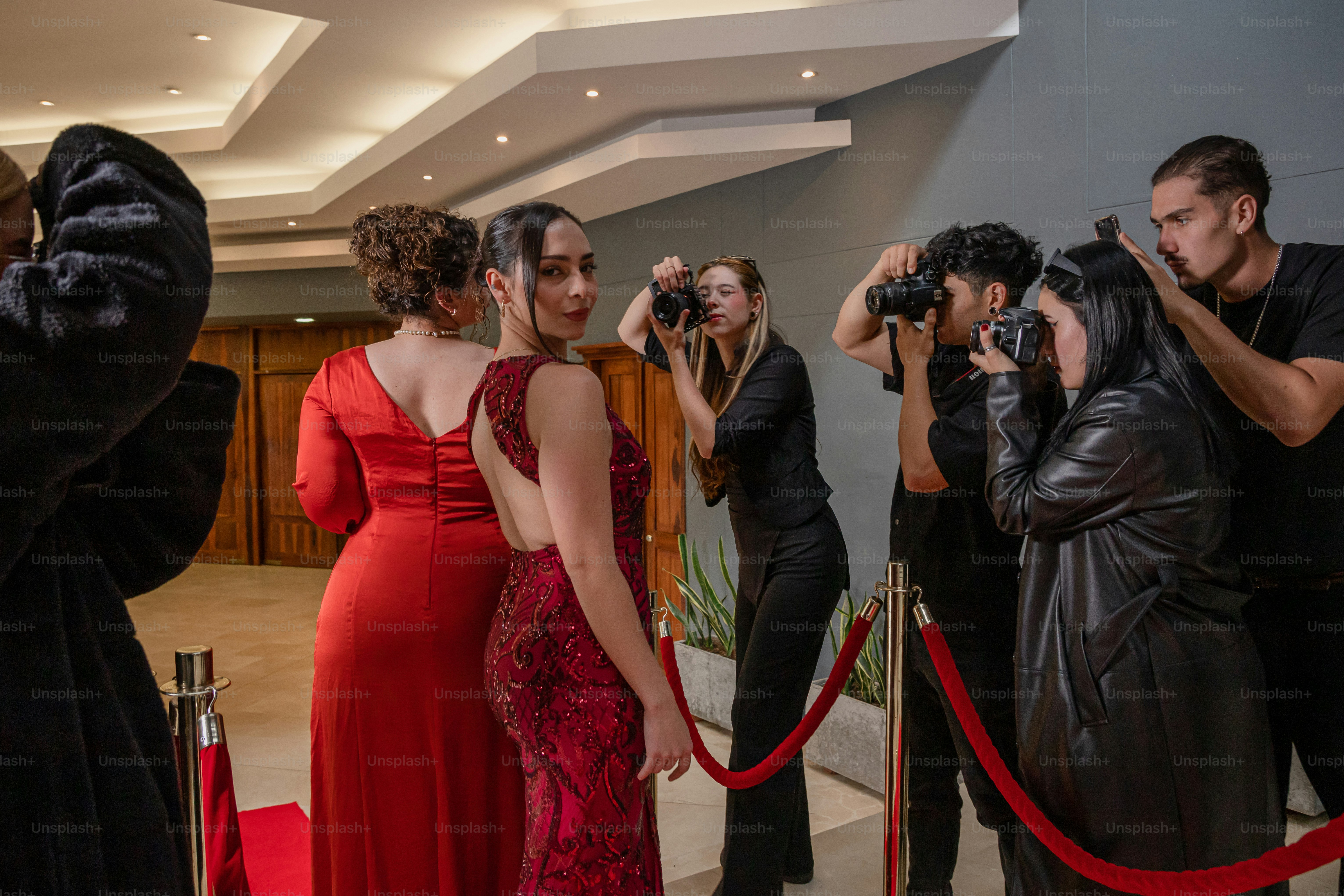 A group of people standing around a red carpet