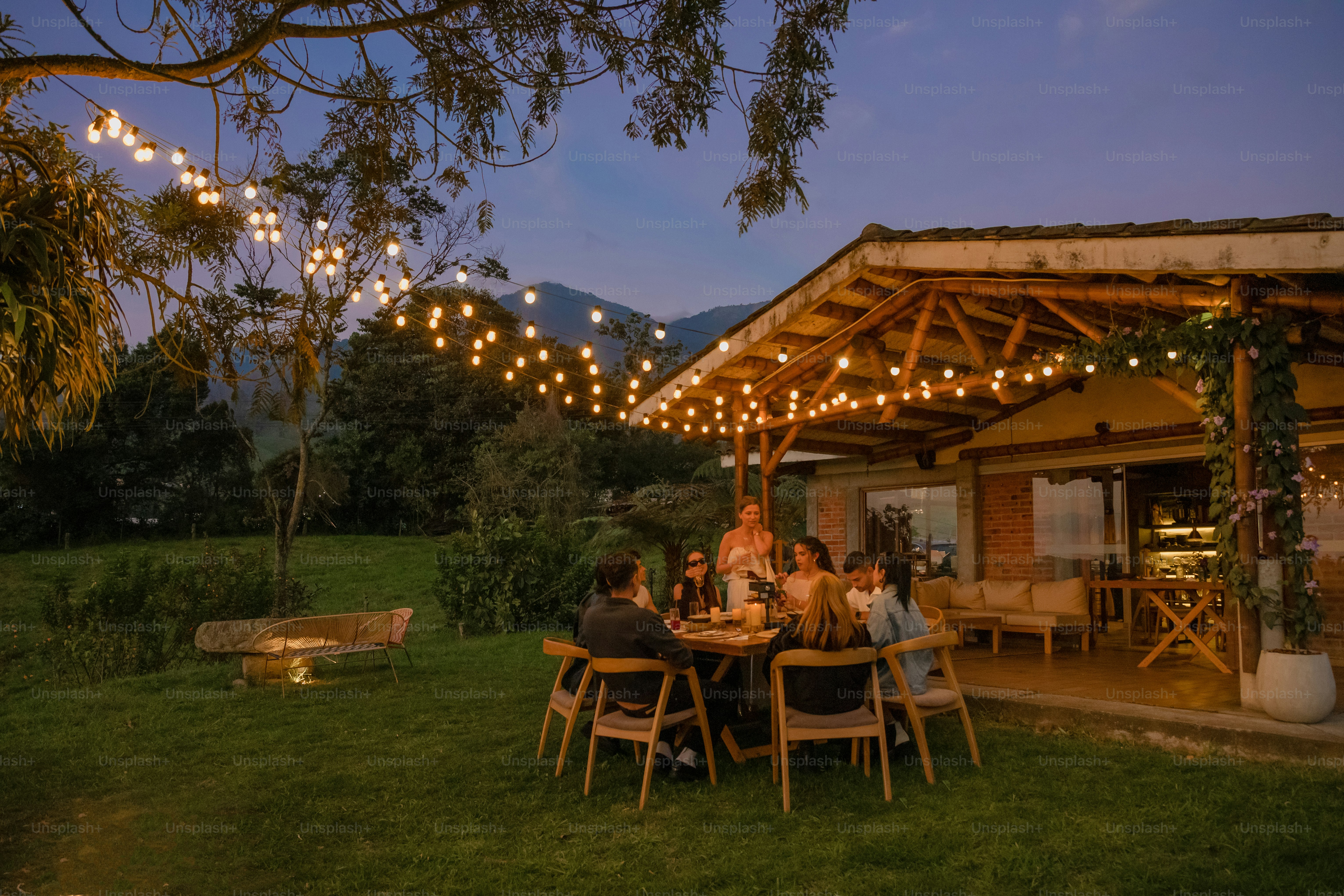 A group of people sitting at a table outside