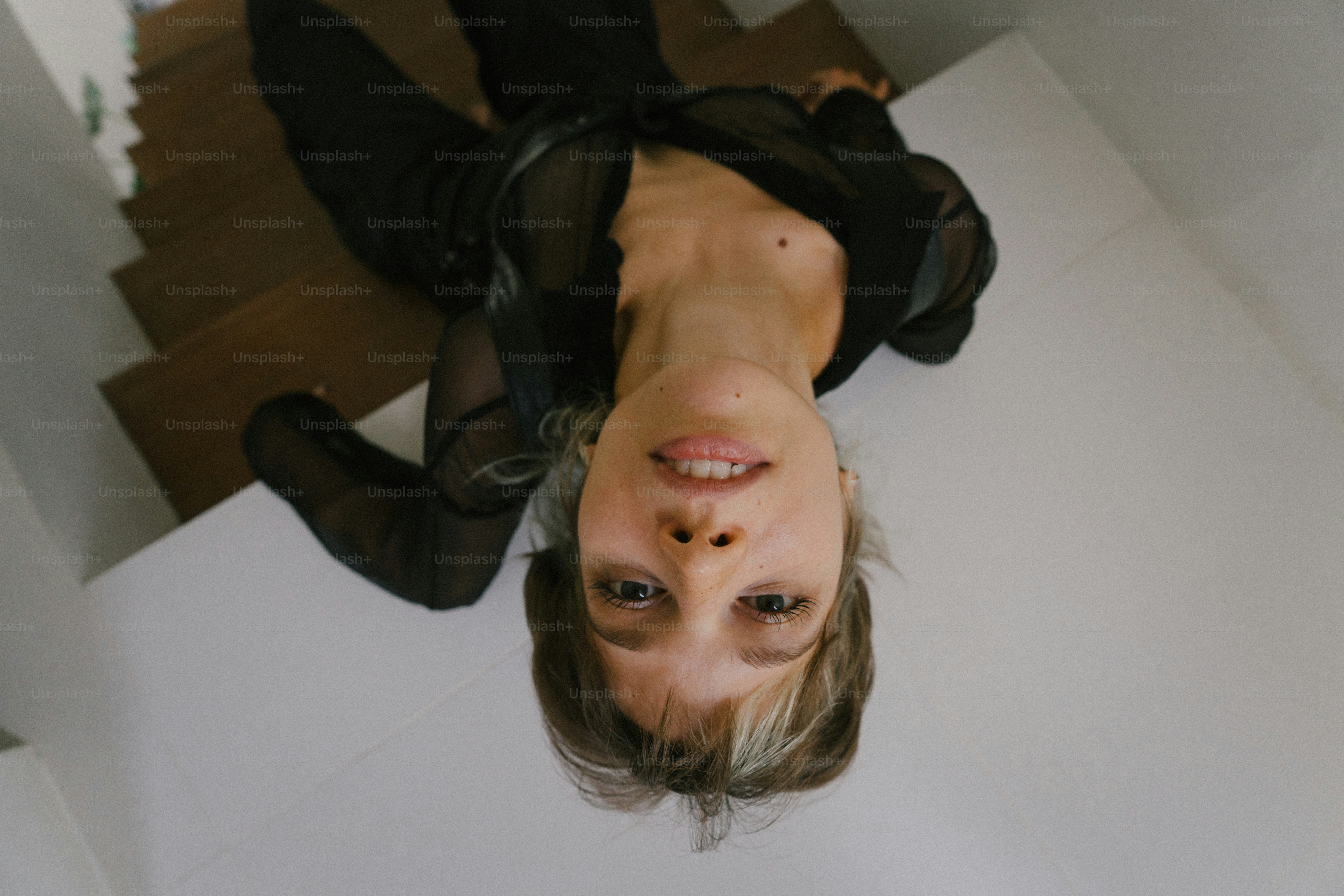 A woman is standing on the floor with her hands in her pockets