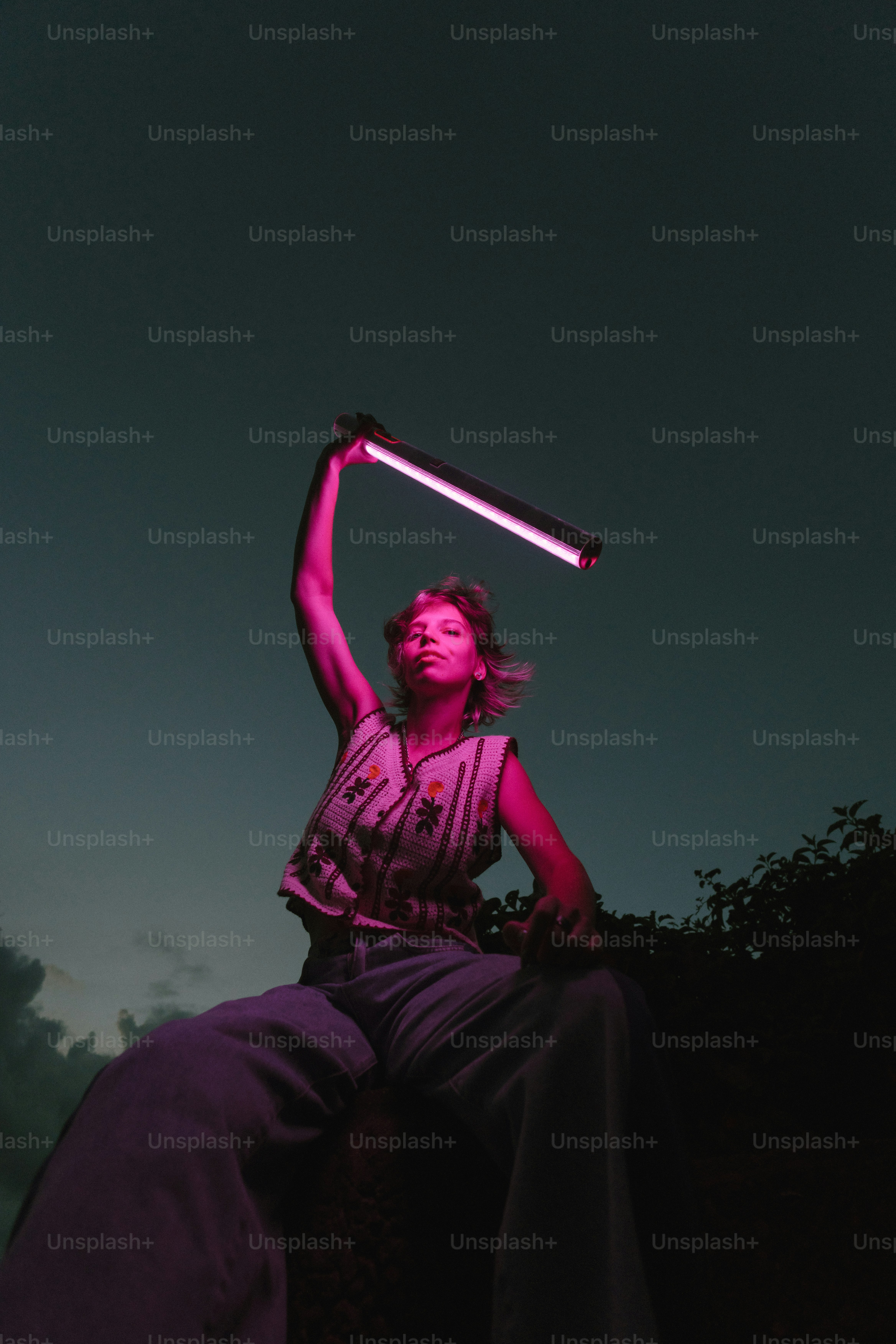 A woman sitting on a rock holding a baseball bat