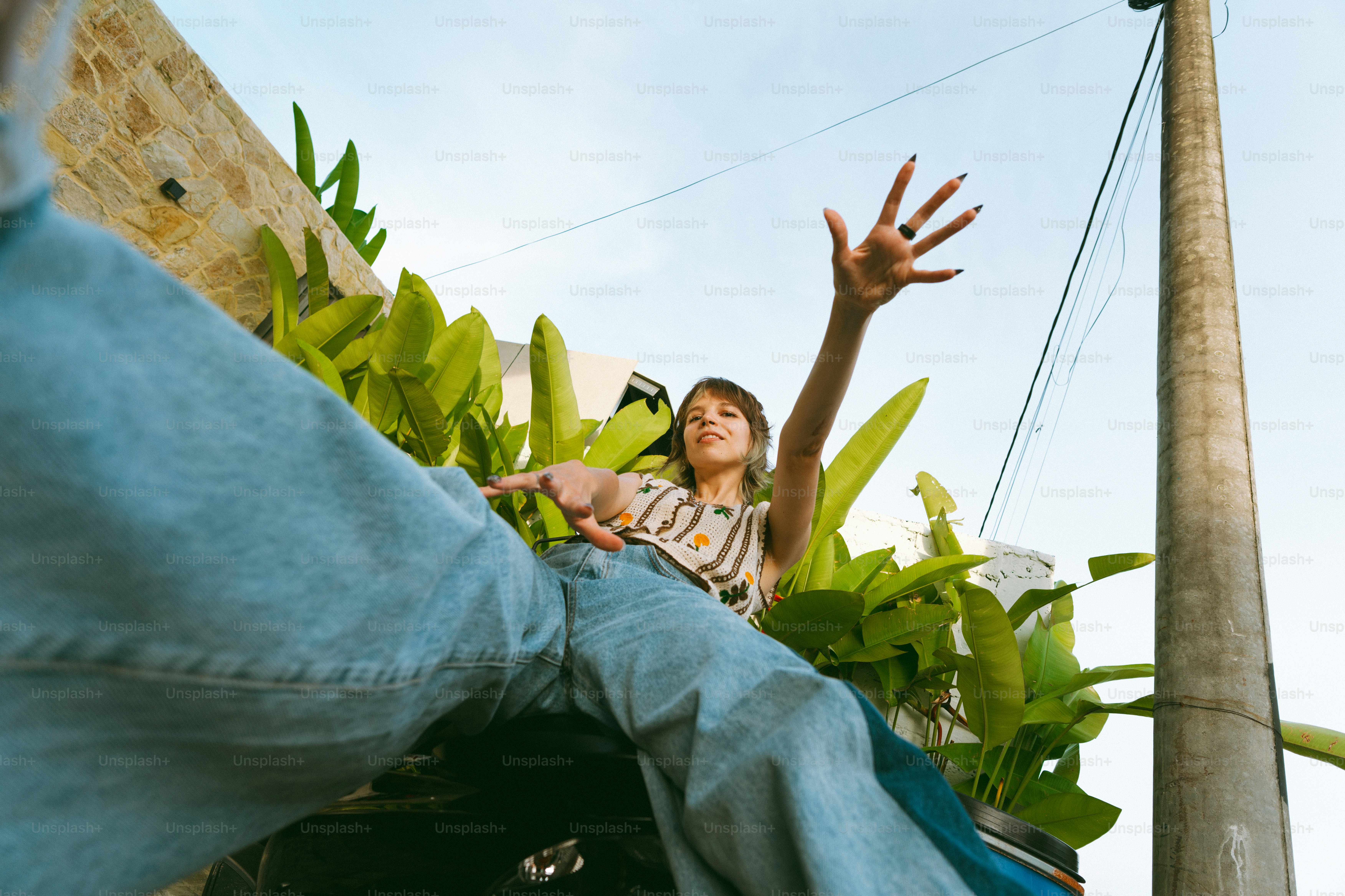 A woman reaching up into the air to catch a frisbee