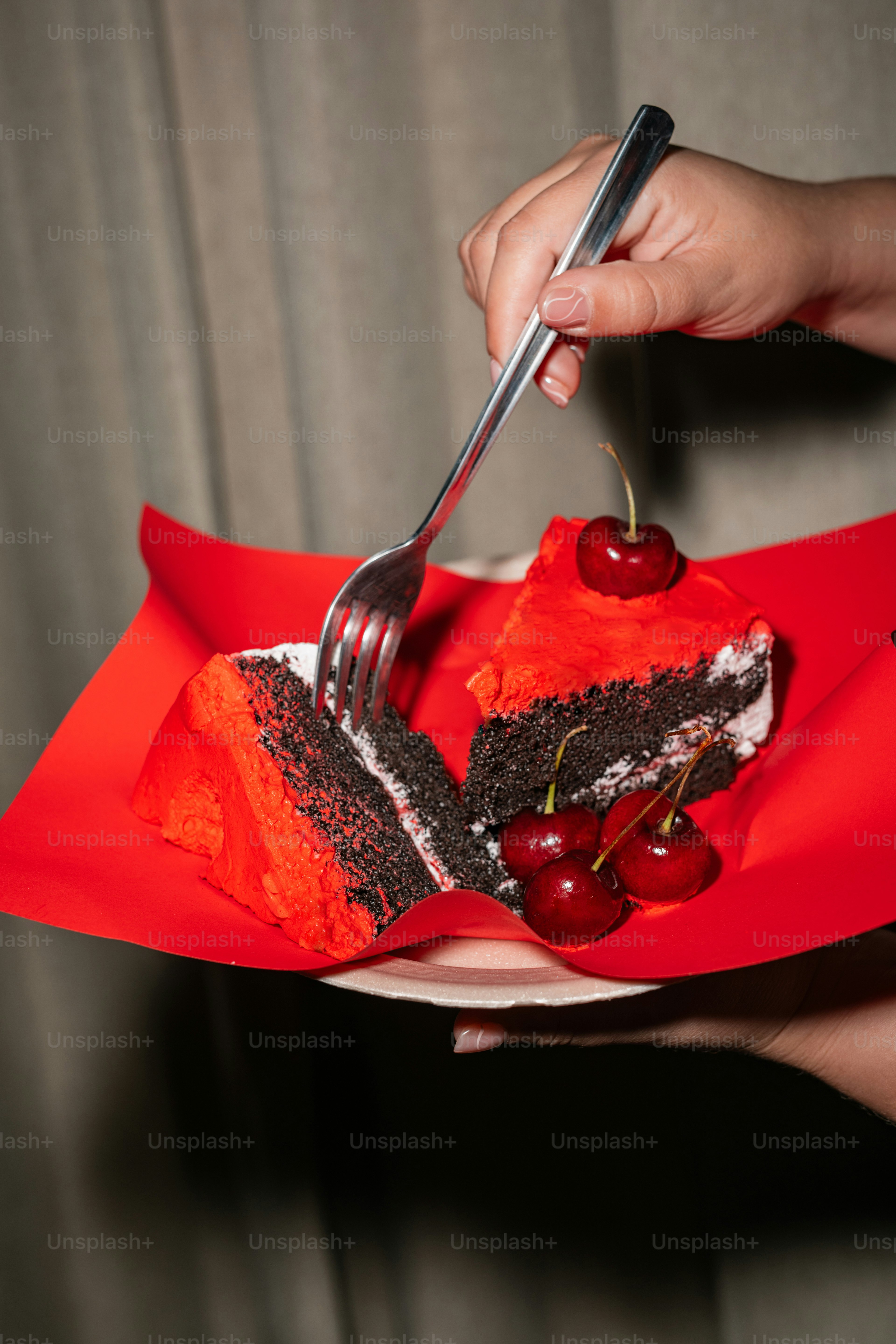 A person holding a fork and a piece of cake