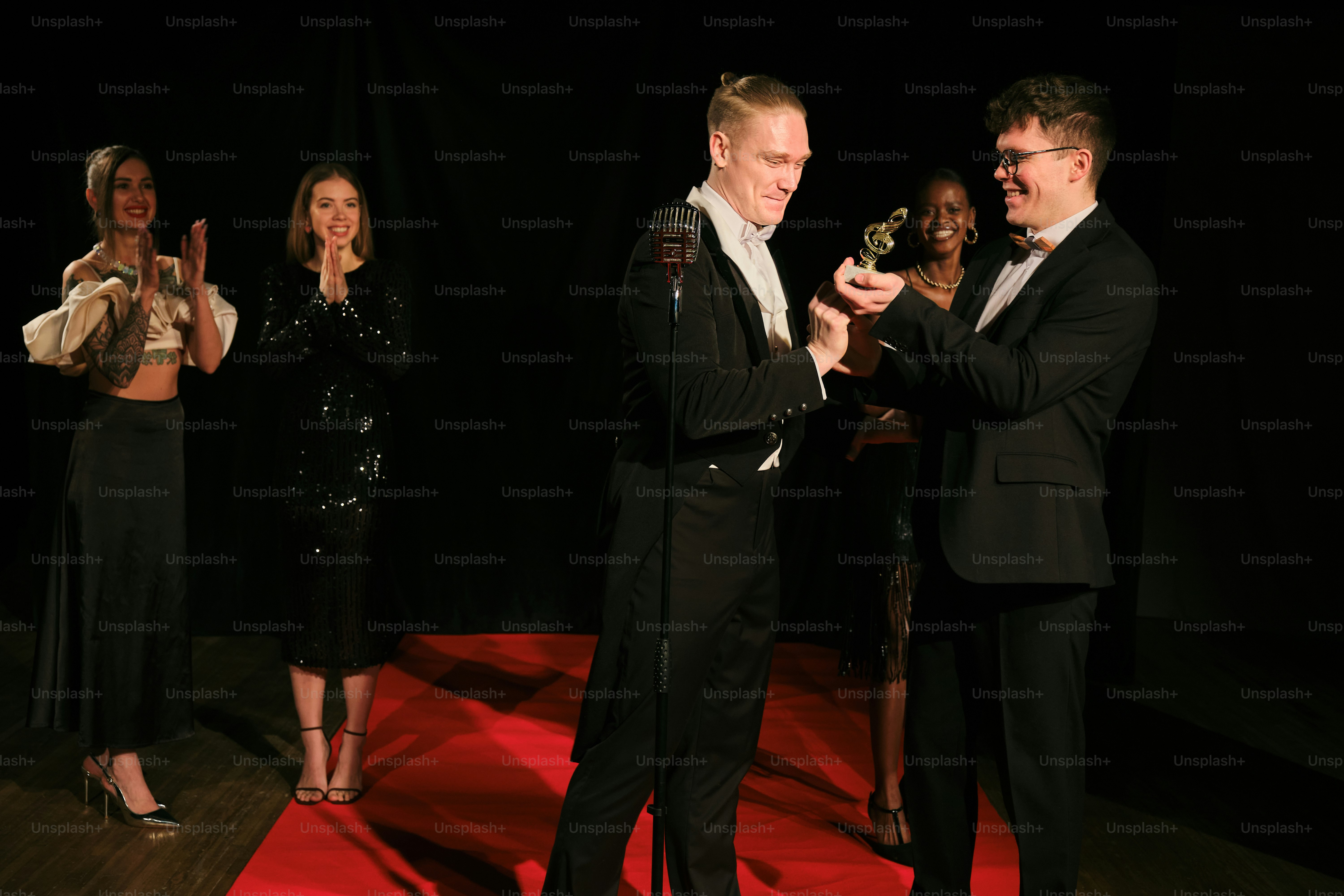 A group of people standing on top of a red carpet
