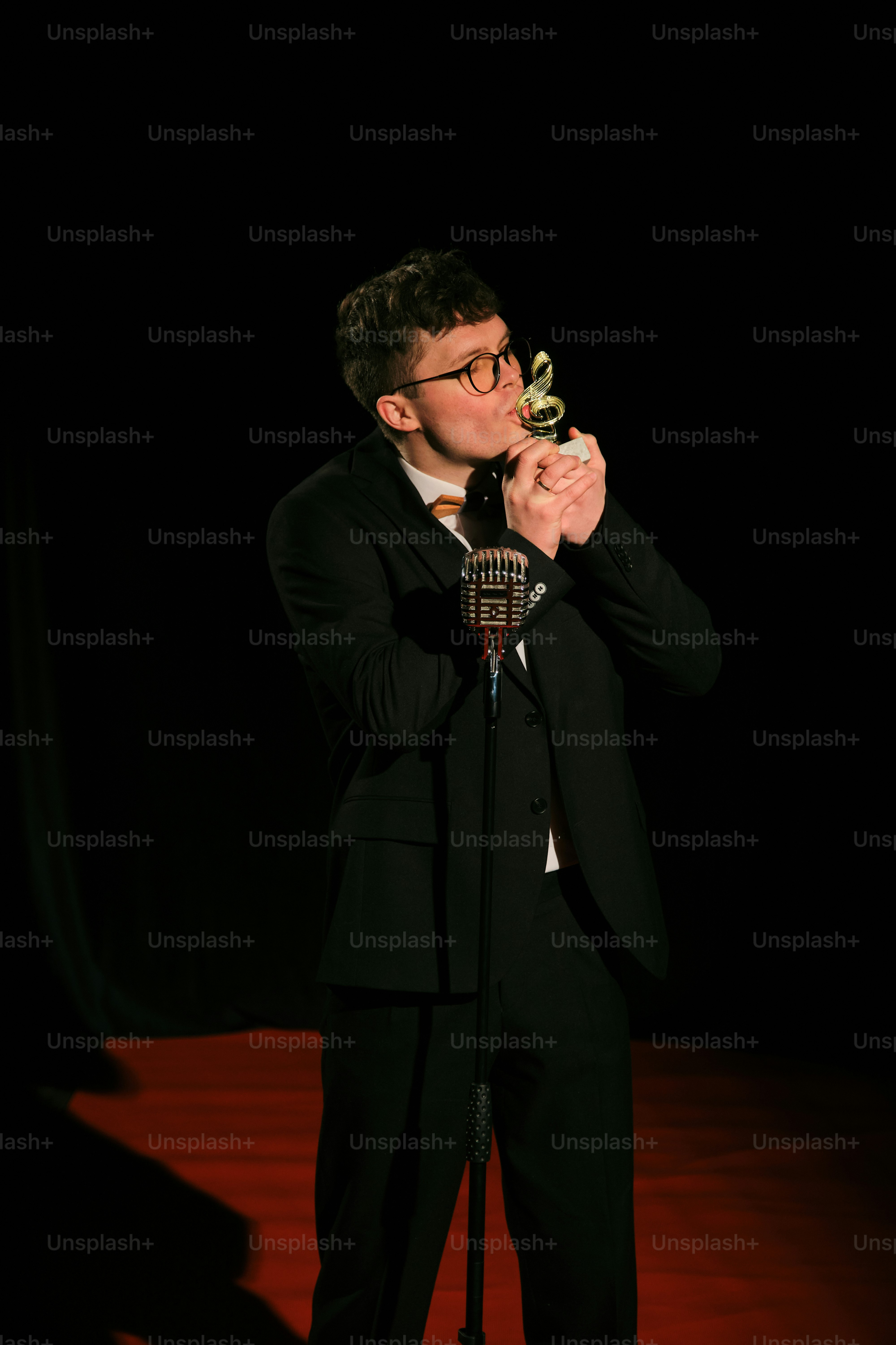 A man in a suit and tie standing in front of a microphone