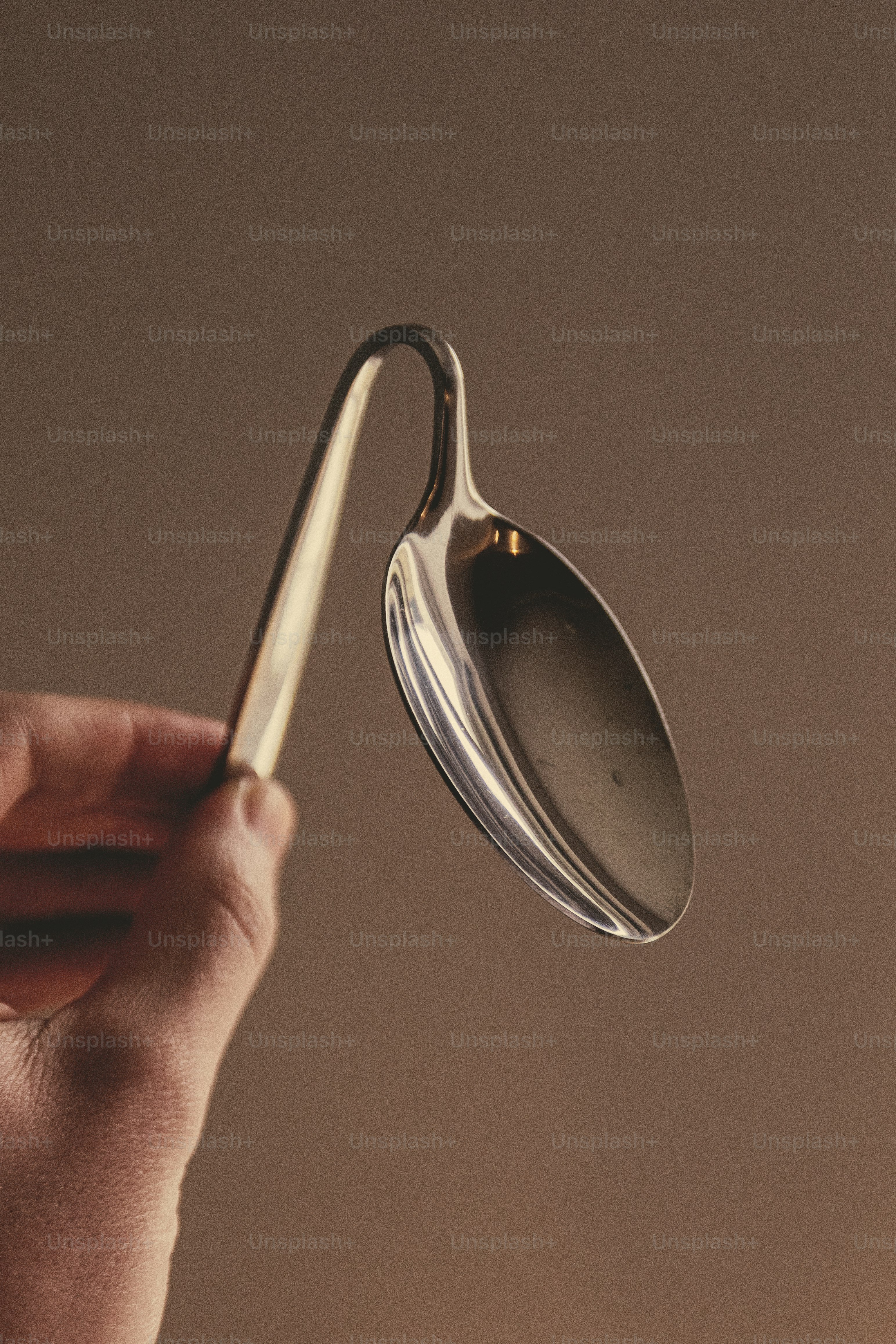 Eine Person hält einen Löffel mit einem Griff