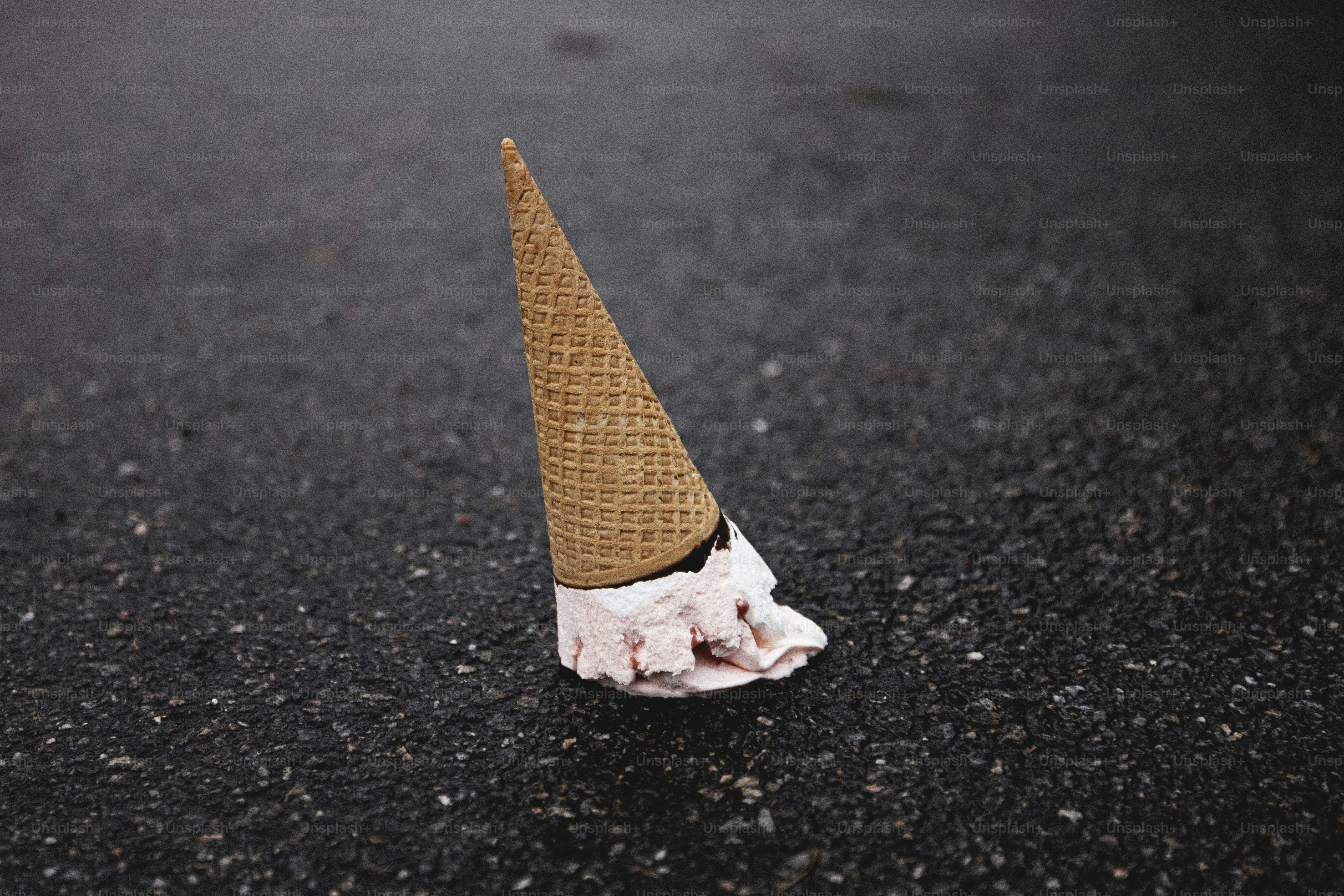 An ice cream cone sitting on the side of a road
