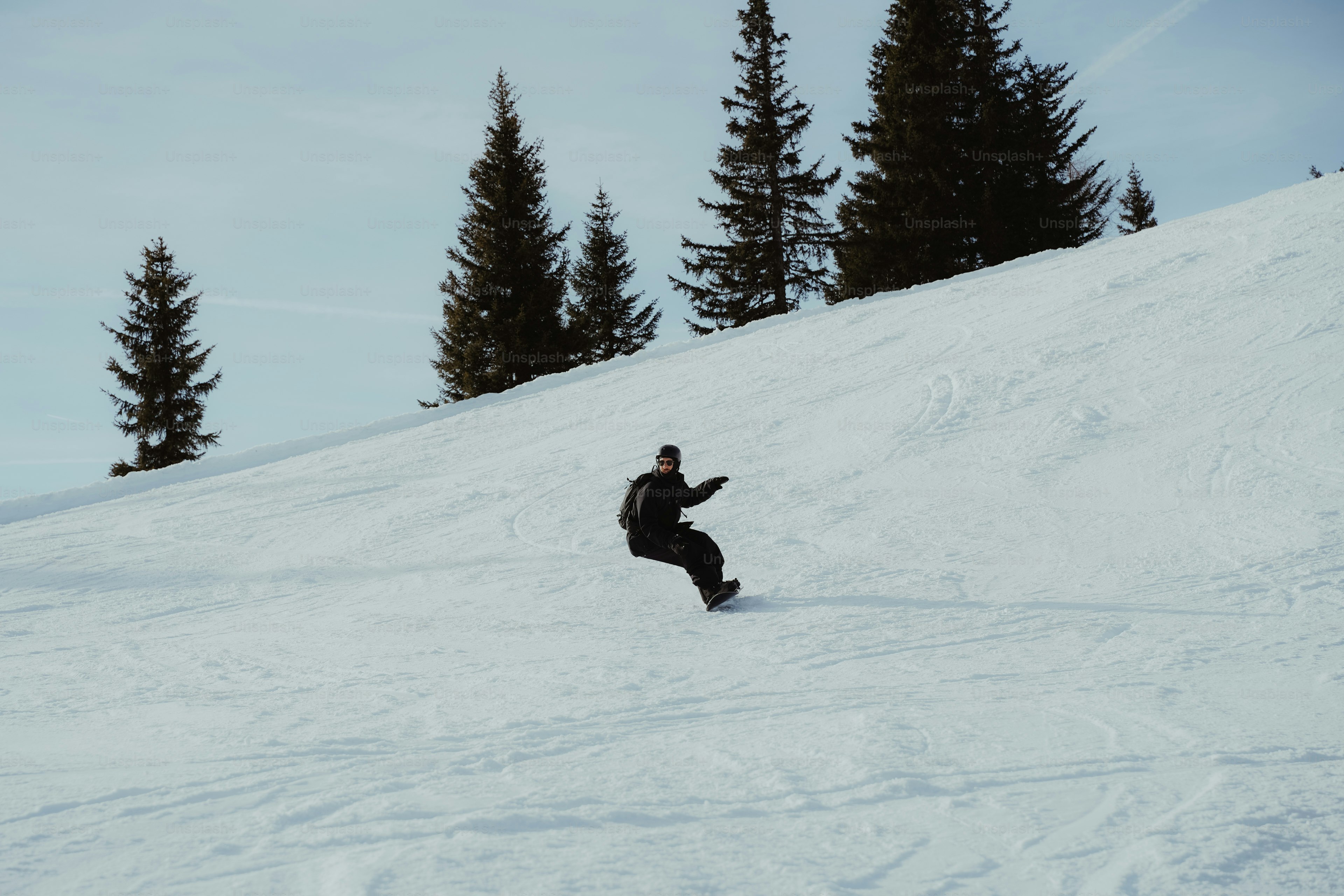A man riding a snowboard down a snow covered slope