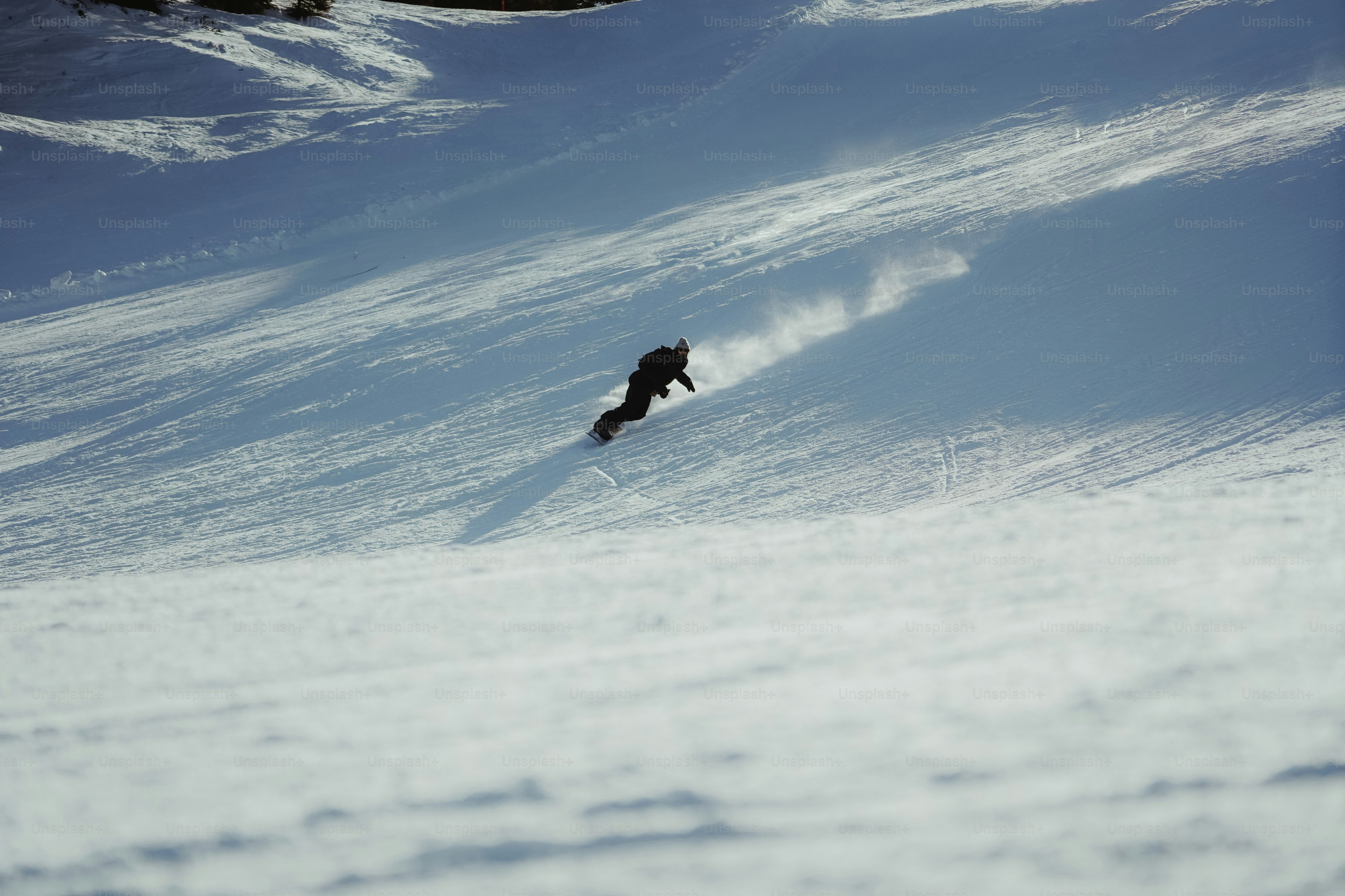 A person riding a snowboard down a snow covered slope