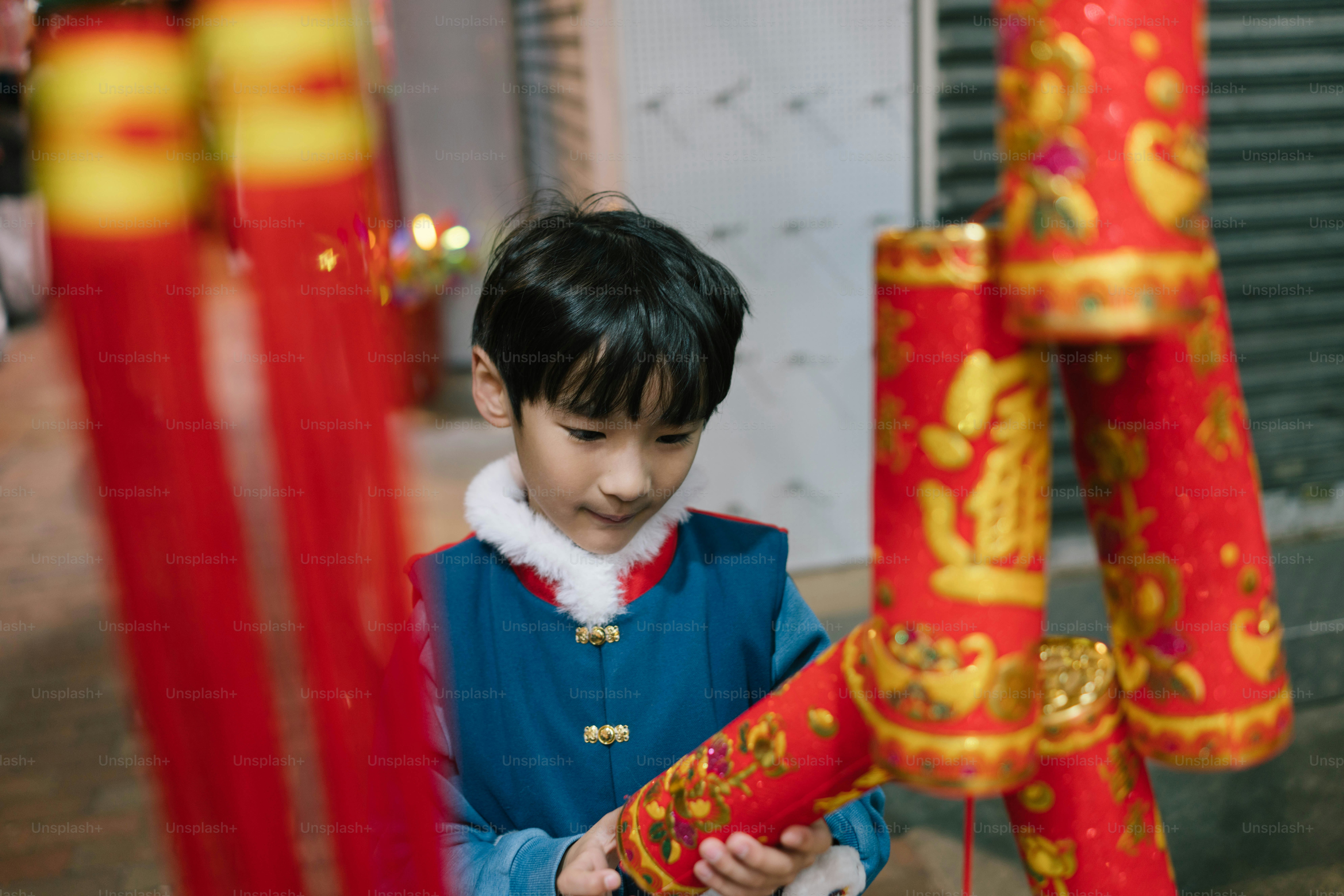 A young boy is looking at a cell phone
