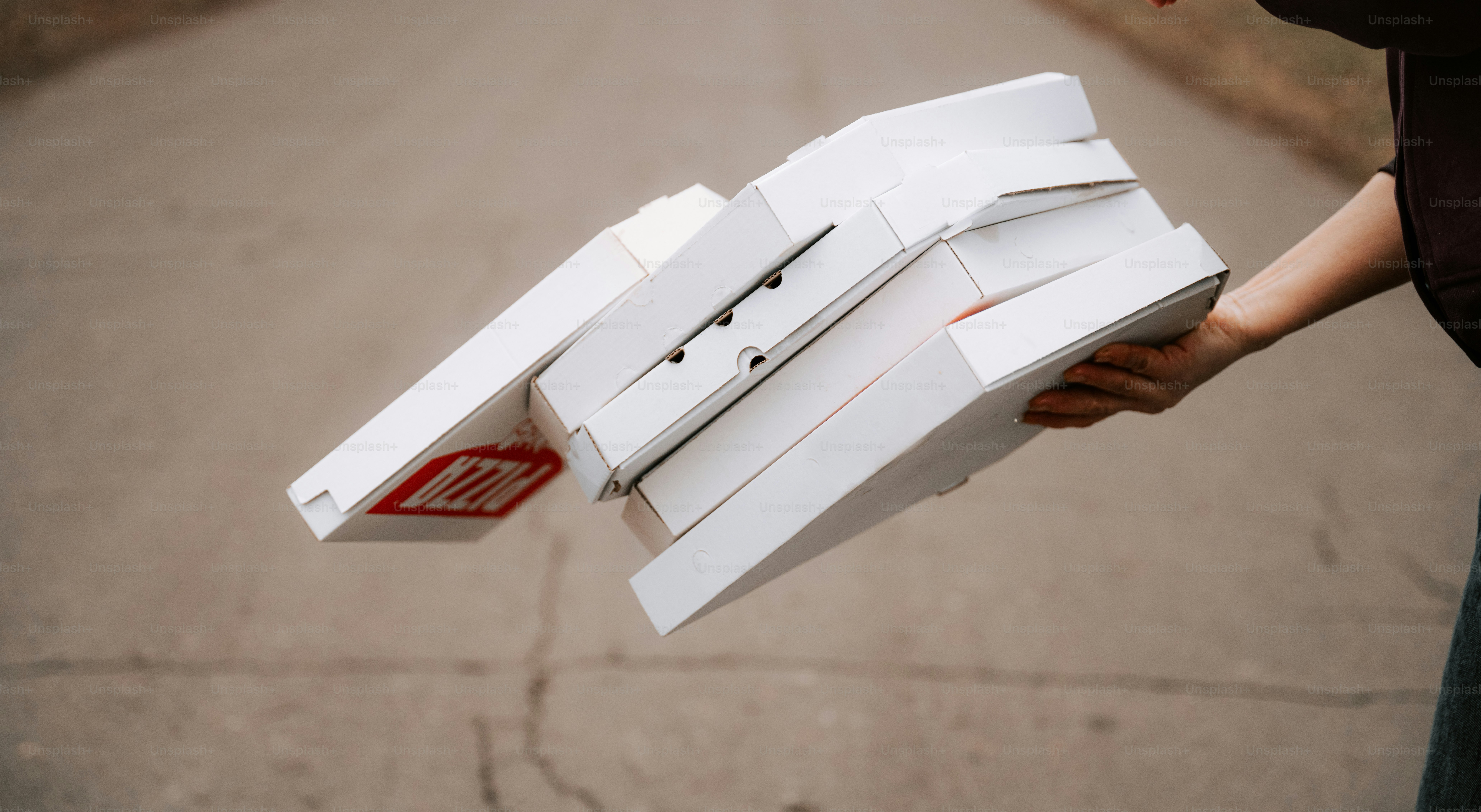 Une personne tenant une boîte de pizza dans la rue