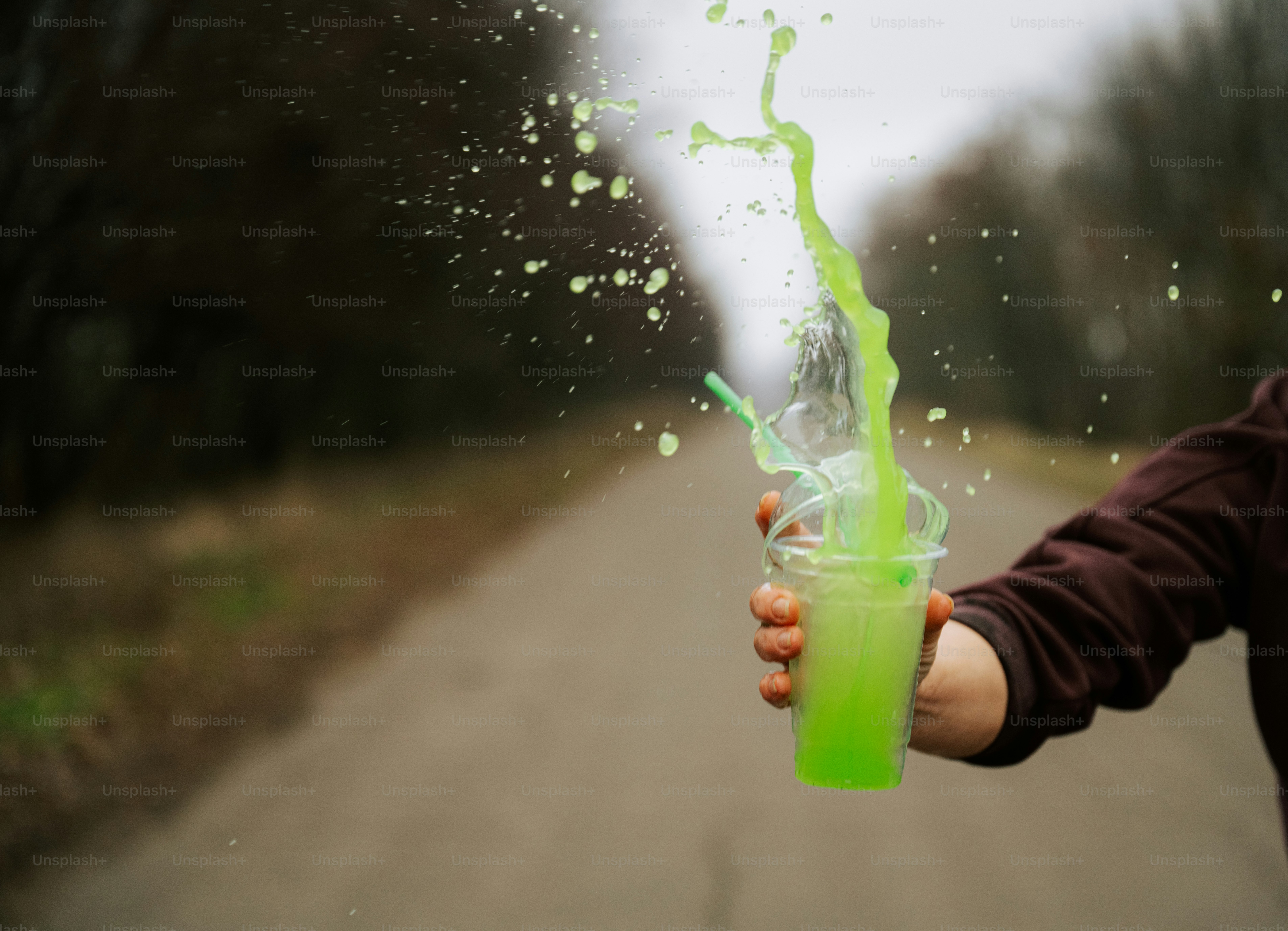 Une personne tenant une boisson verte à la main