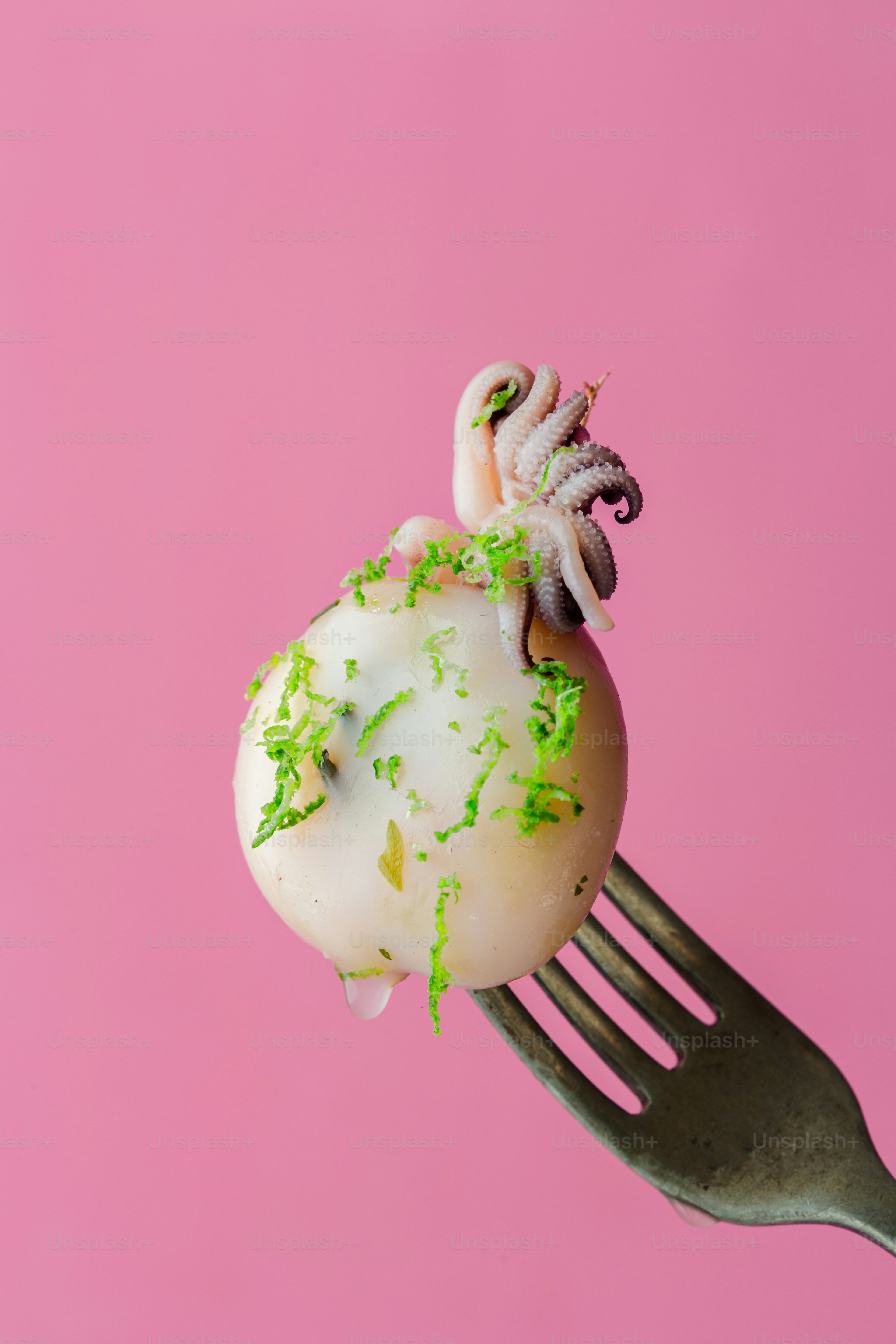 Un trozo de pastel en un tenedor sobre un fondo rosa