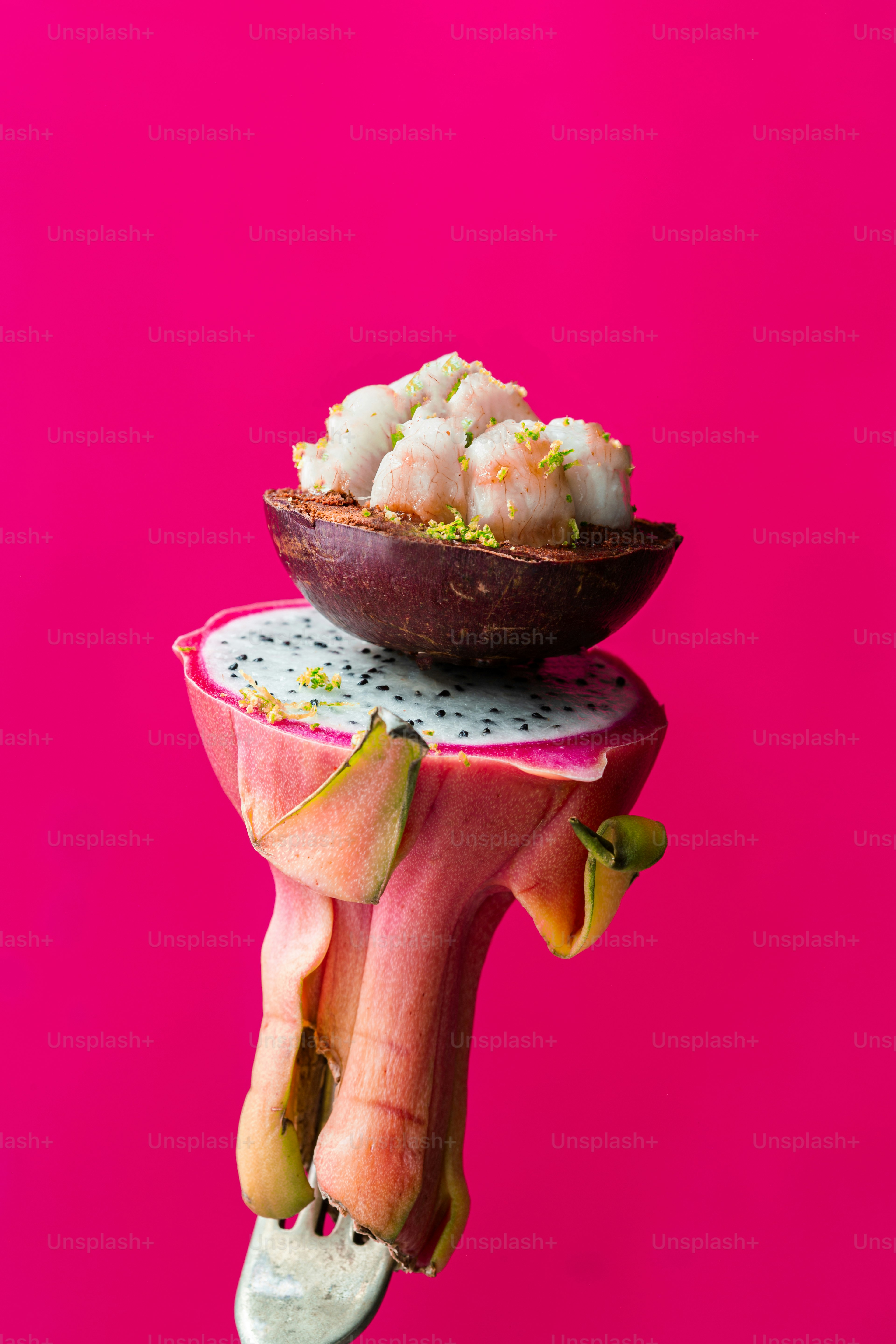 Una mano sosteniendo un plato de comida sobre un fondo rosa