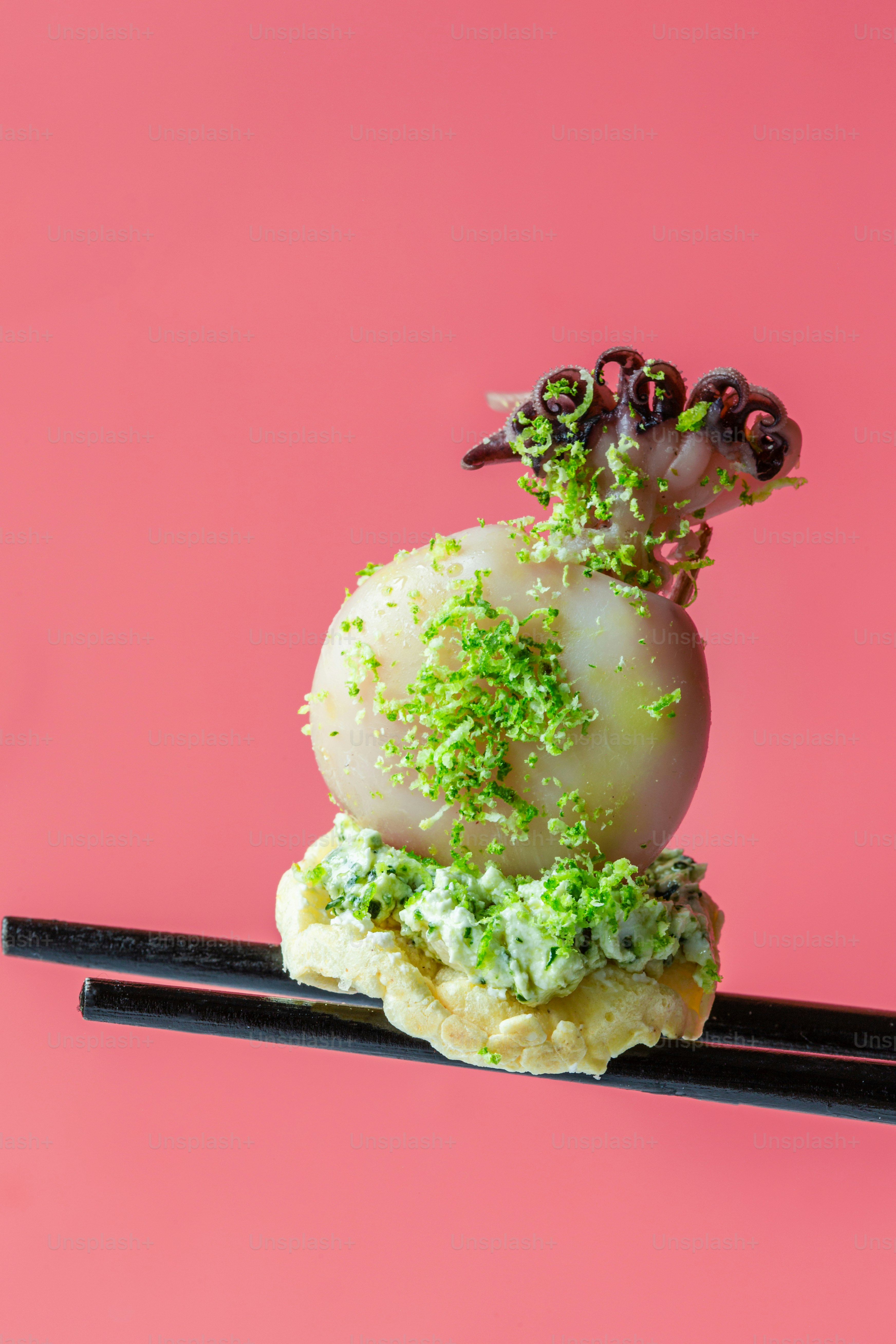 Un pedazo de comida que está sentado sobre unos palillos