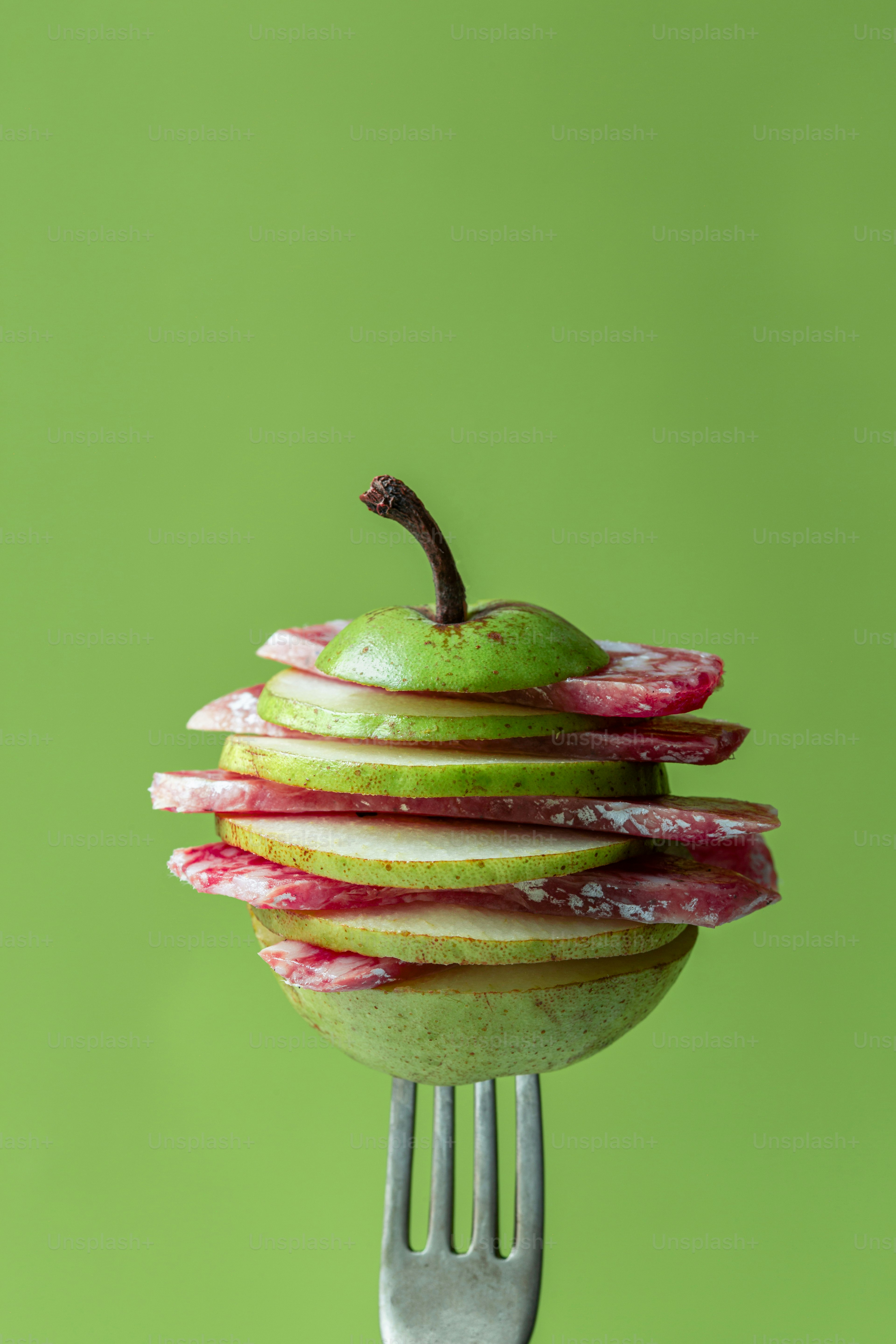 Un tenedor con una pila de manzanas encima