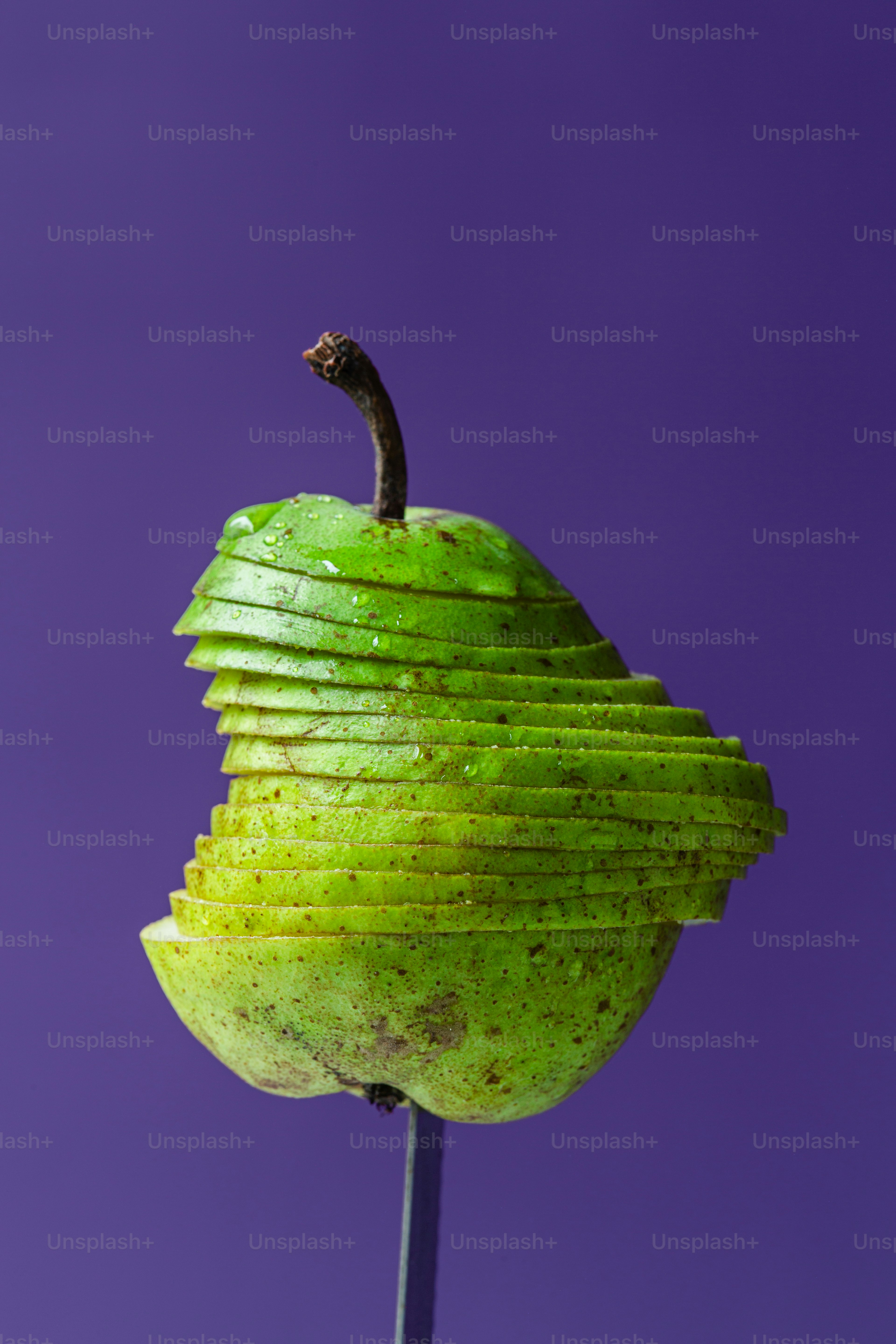 Una manzana verde sentada encima de un palo de madera