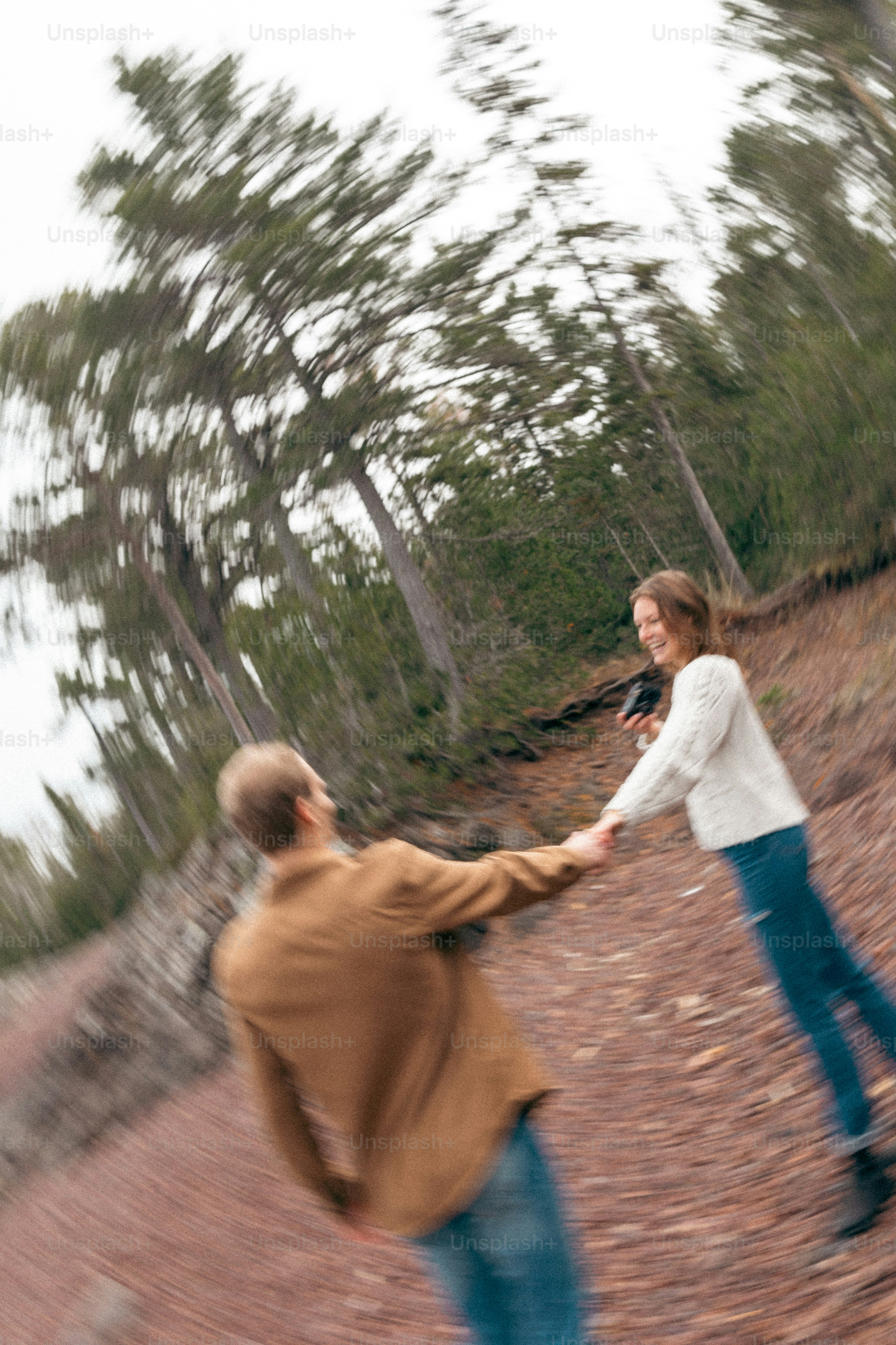 A man and a woman holding hands in the woods