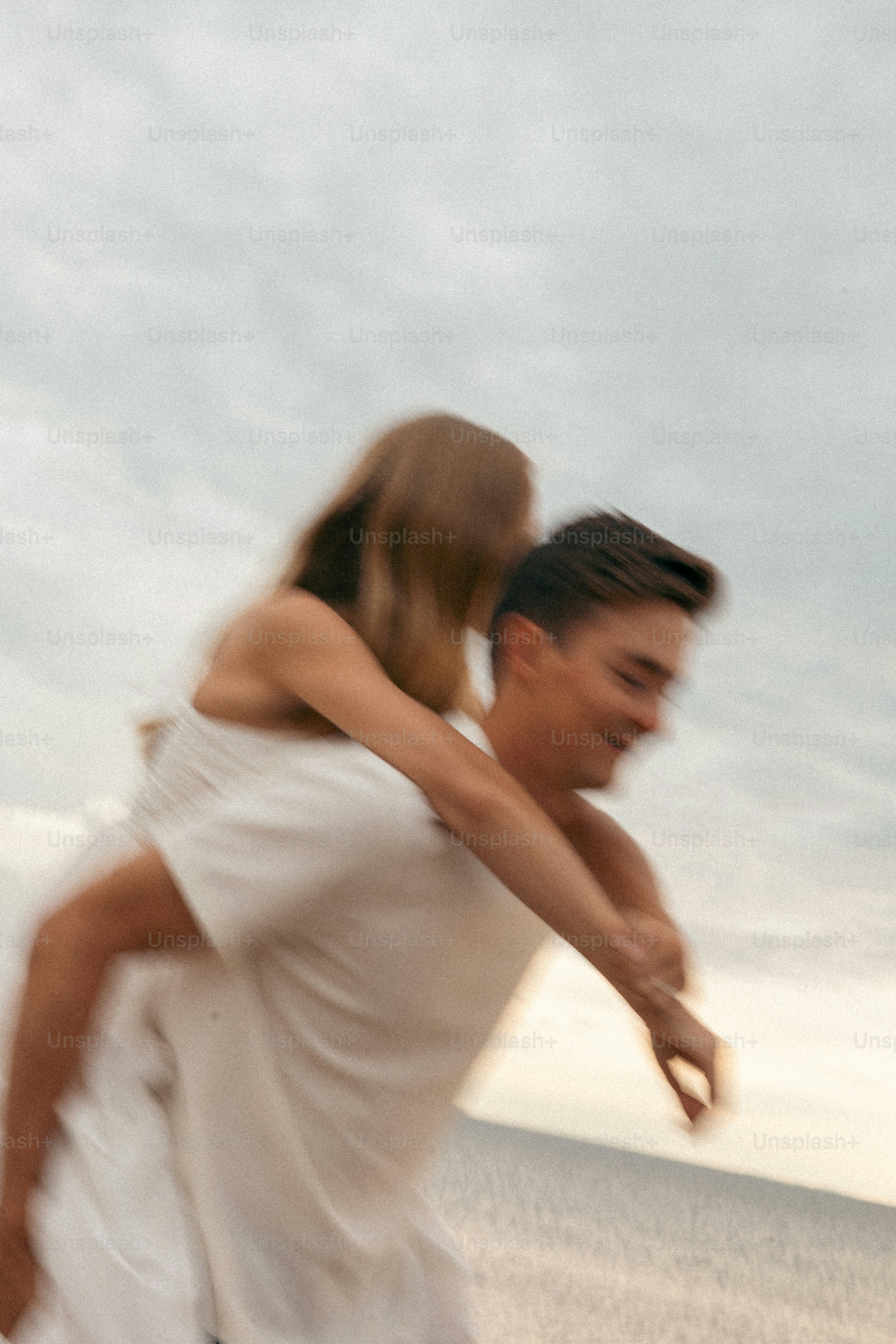 A man carrying a woman on his back on the beach
